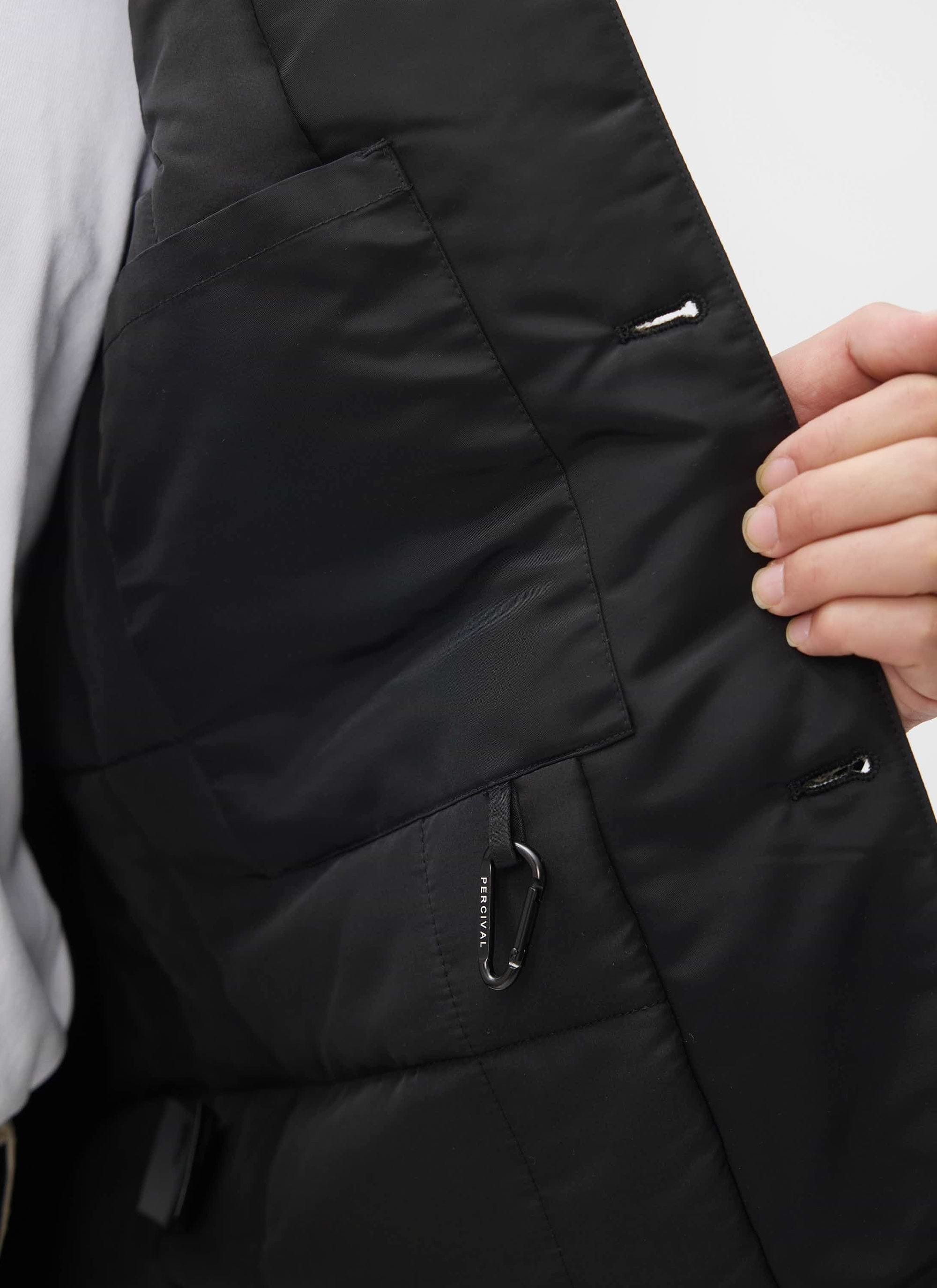 A close-up of the internal patch pocket and branded carabiner inside the quilted lining of the Percival Doppio Bomber Jacket.