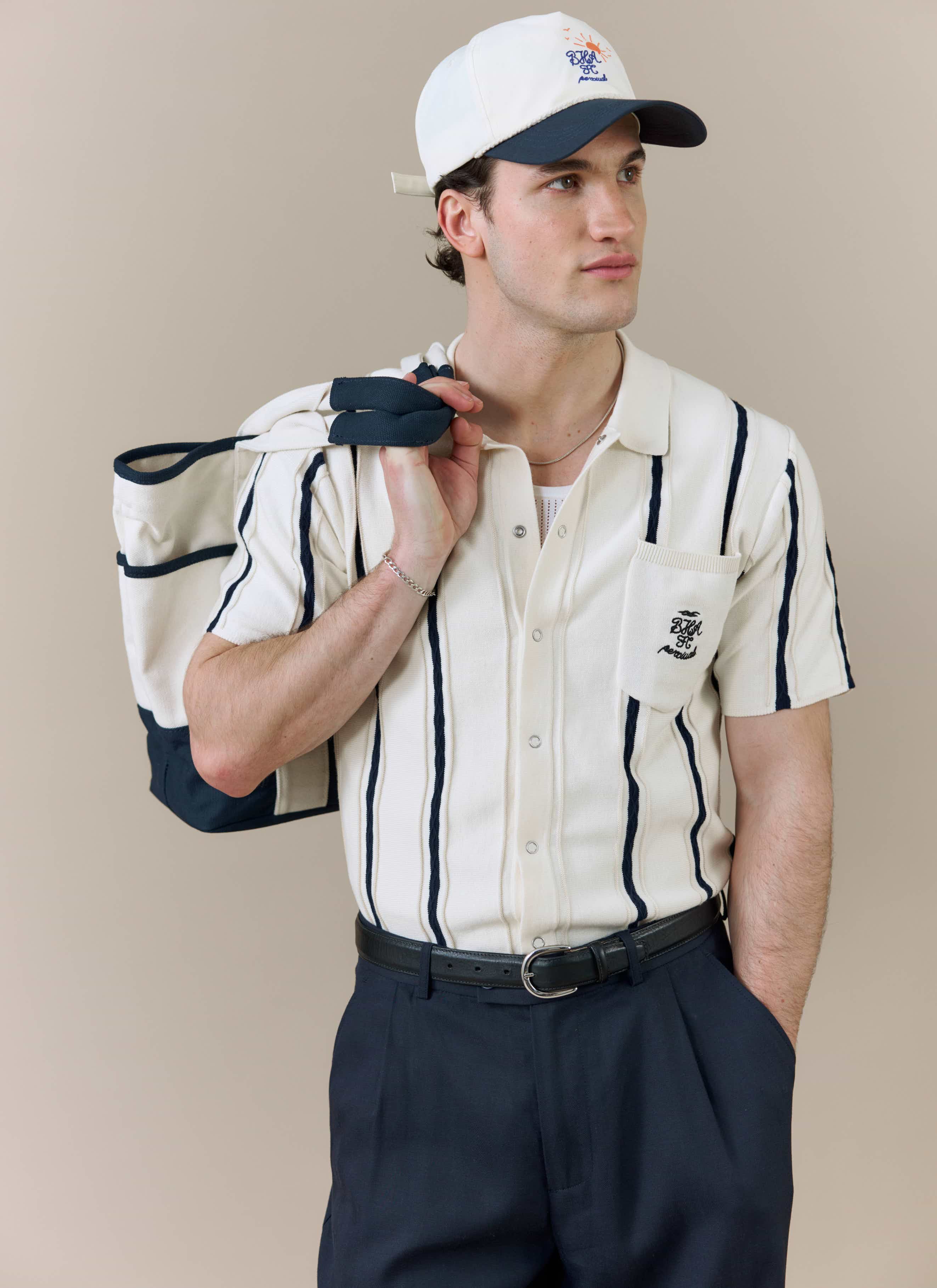 A model wearing the white Cable Stripe Knitted Shirt from the Percival x Brighton & Hove Albion F.C. collaboration.