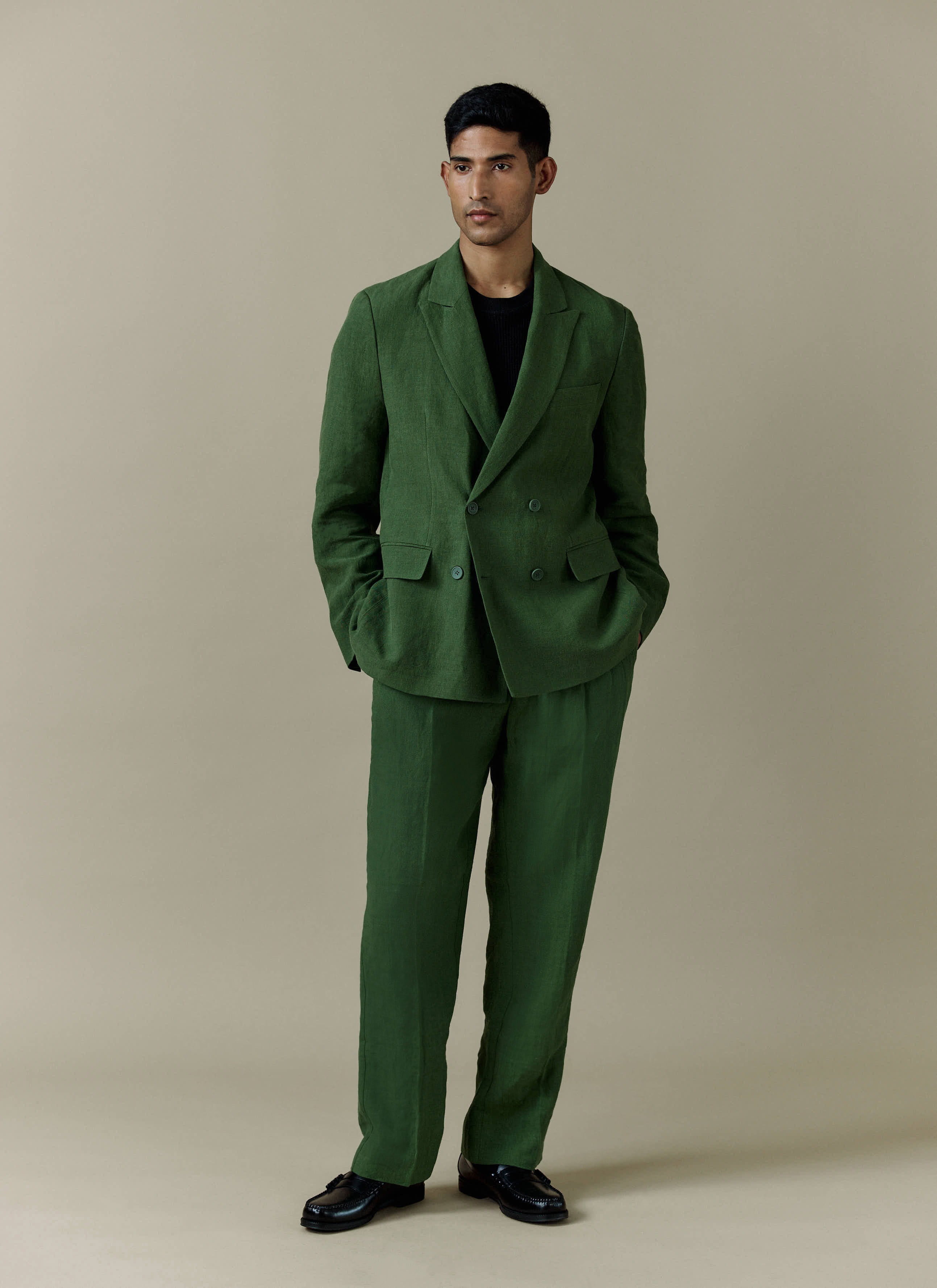 Percival forest green linen suit featuring pleated tailored trousers and a matching double-breasted blazer.