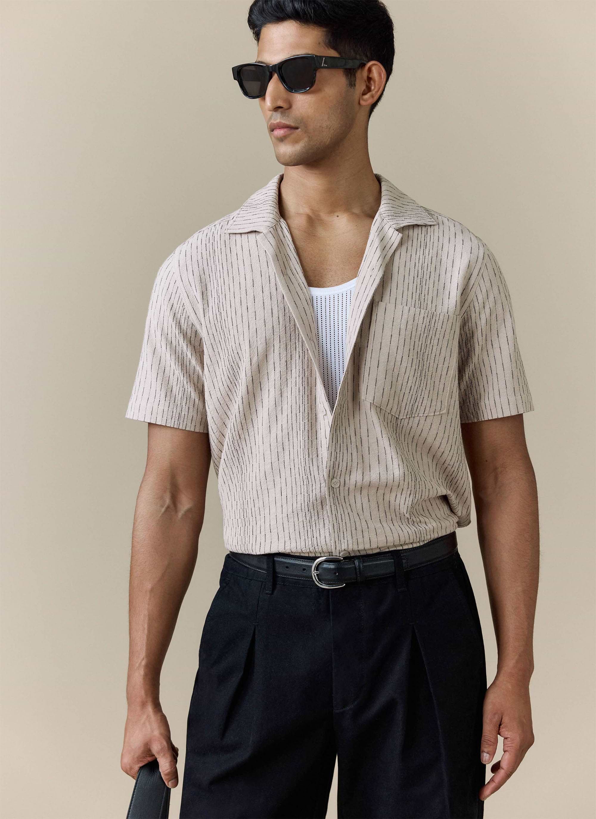 Percival Leland Cuban Shirt in cream cotton with thin vertical stripes, worn by a model over a white vest.