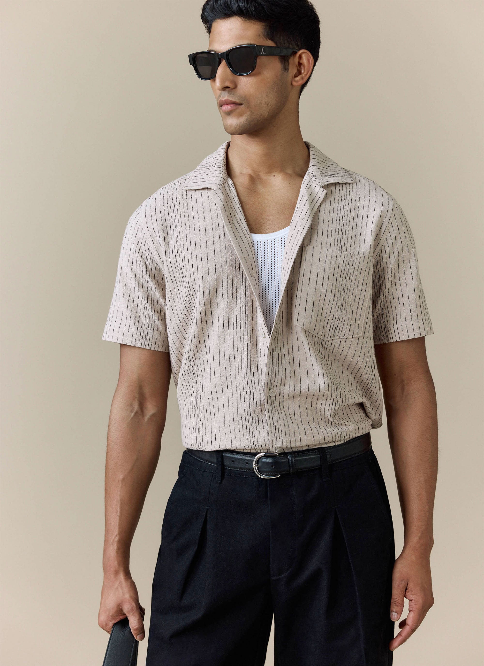 Percival Leland Cuban Shirt in cream cotton with thin vertical stripes, worn by a model over a white vest.