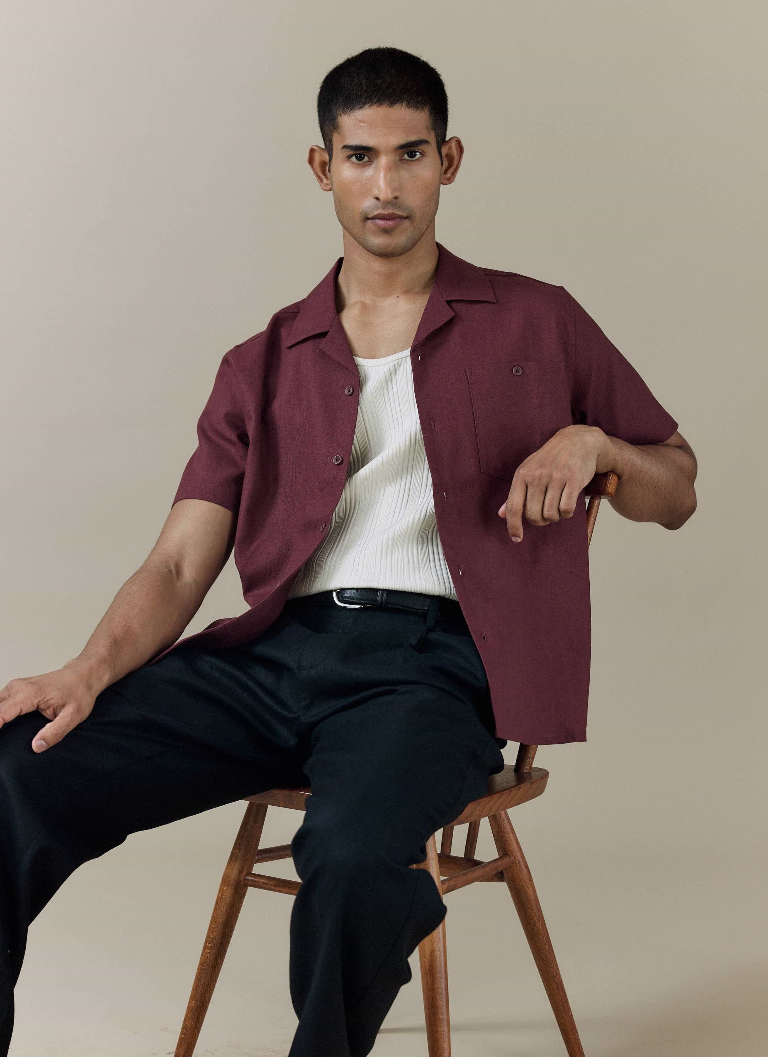 Percival Short Sleeve Cuban Shirt in Merlot linen-cotton blend, styled open over a white ribbed vest and trousers.