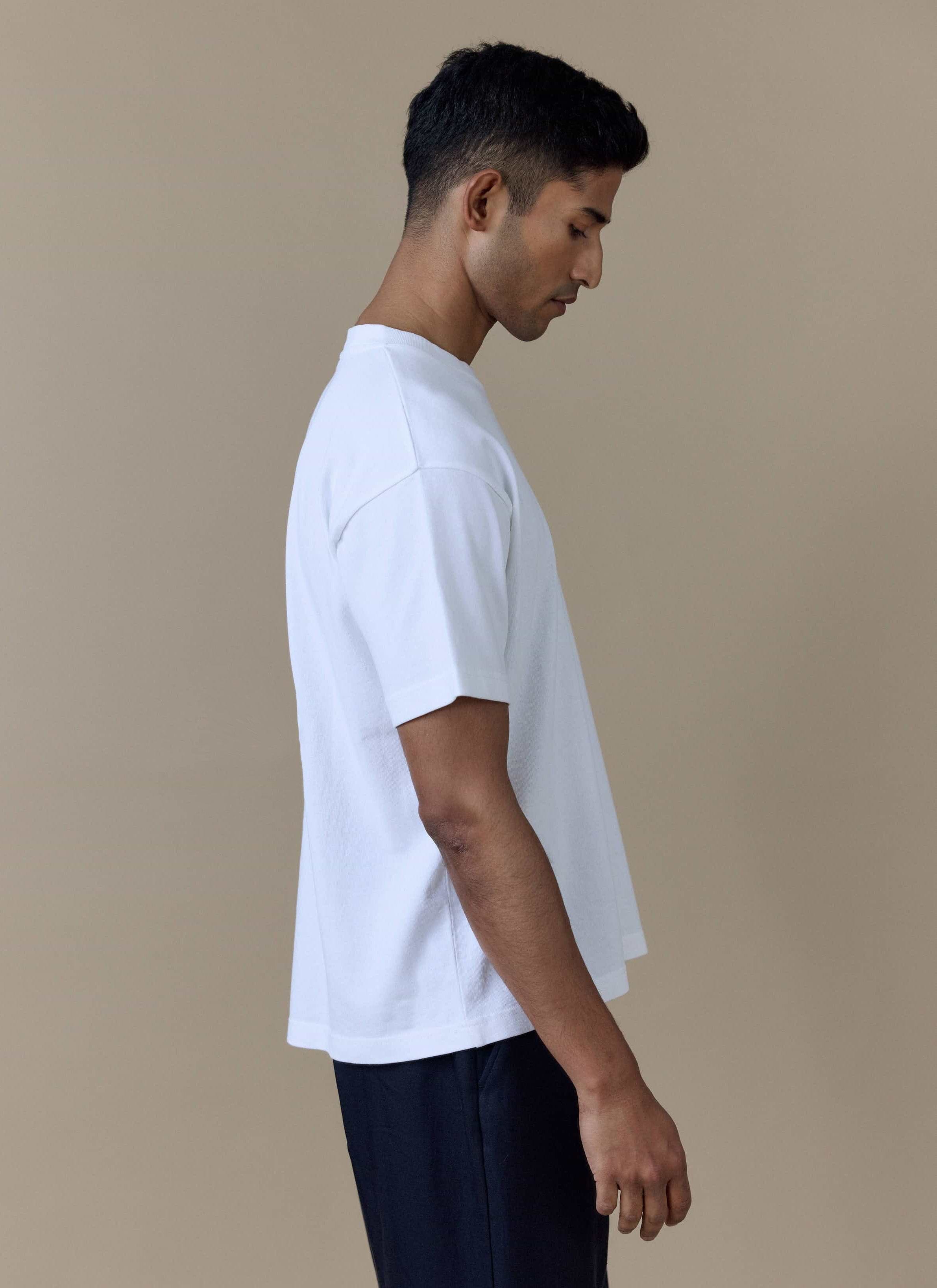 Side view of a model wearing the white Guinness x Percival Printed Oversized T-Shirt.
