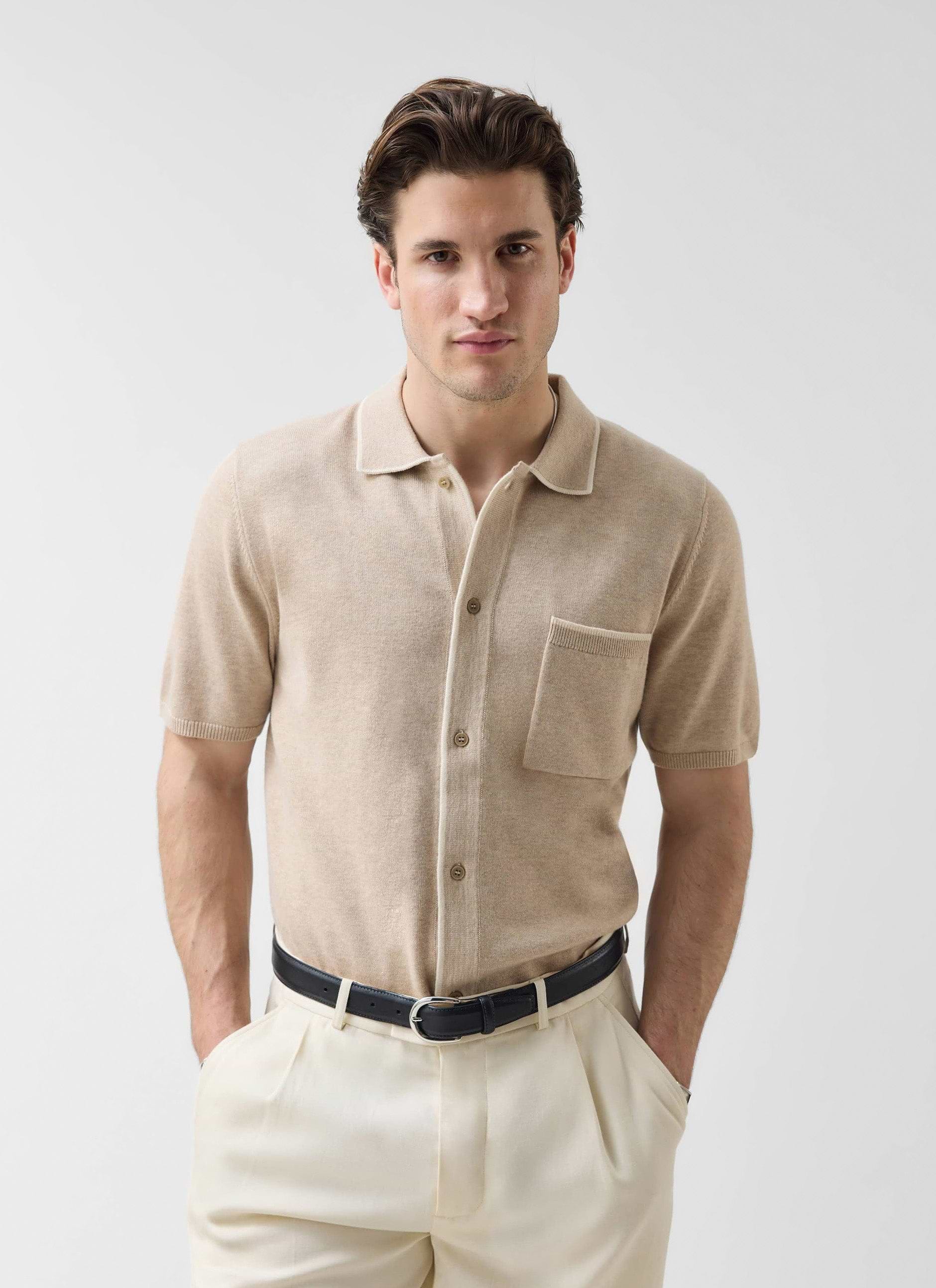A male model wears the Percival Contrast Trim Regular Knitted Shirt in beige, styled with cream trousers and a black belt.