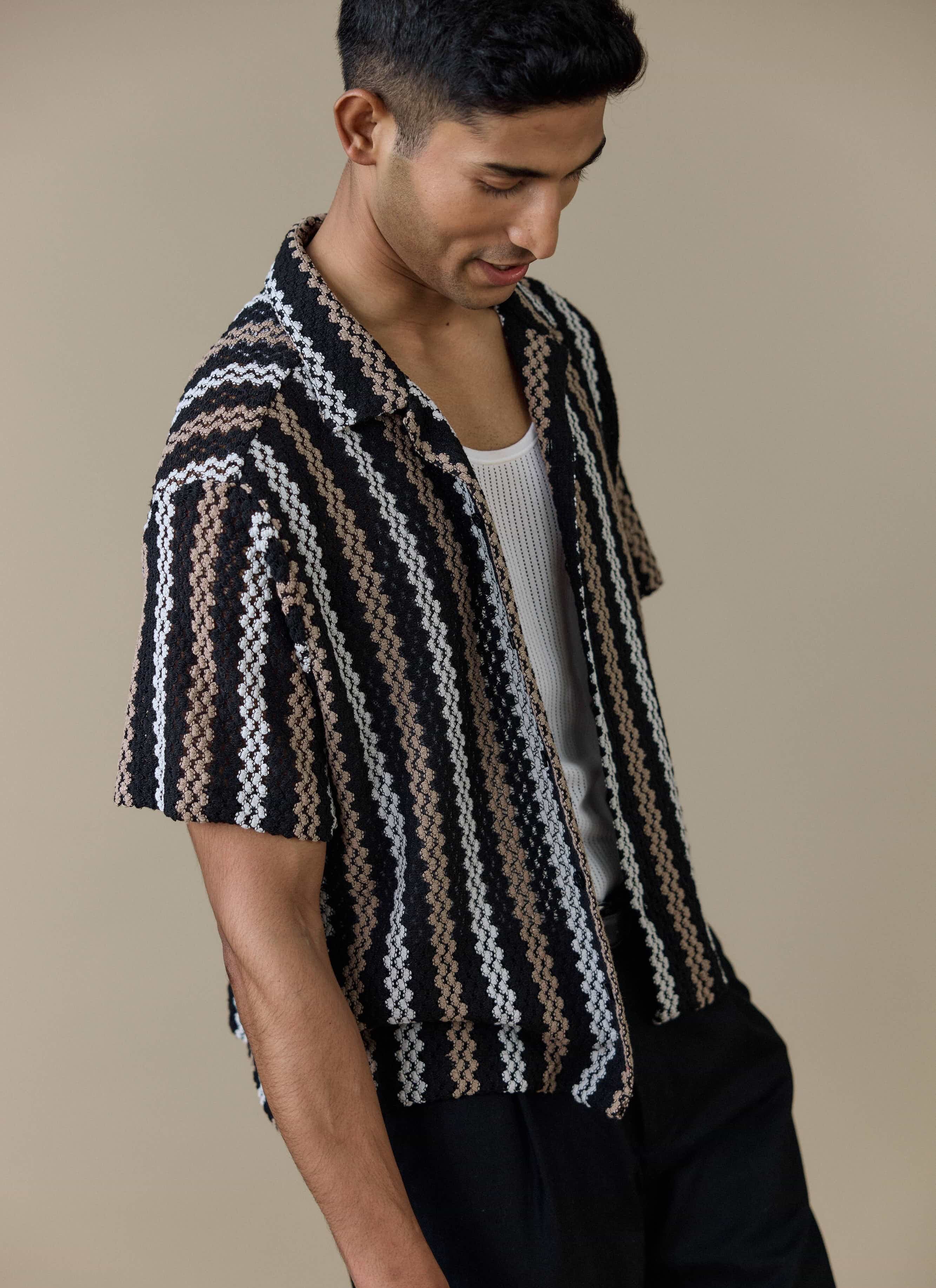 A model wears the black Percival Wade Crochet Boxy Shirt, featuring a textured open crochet stripe pattern.