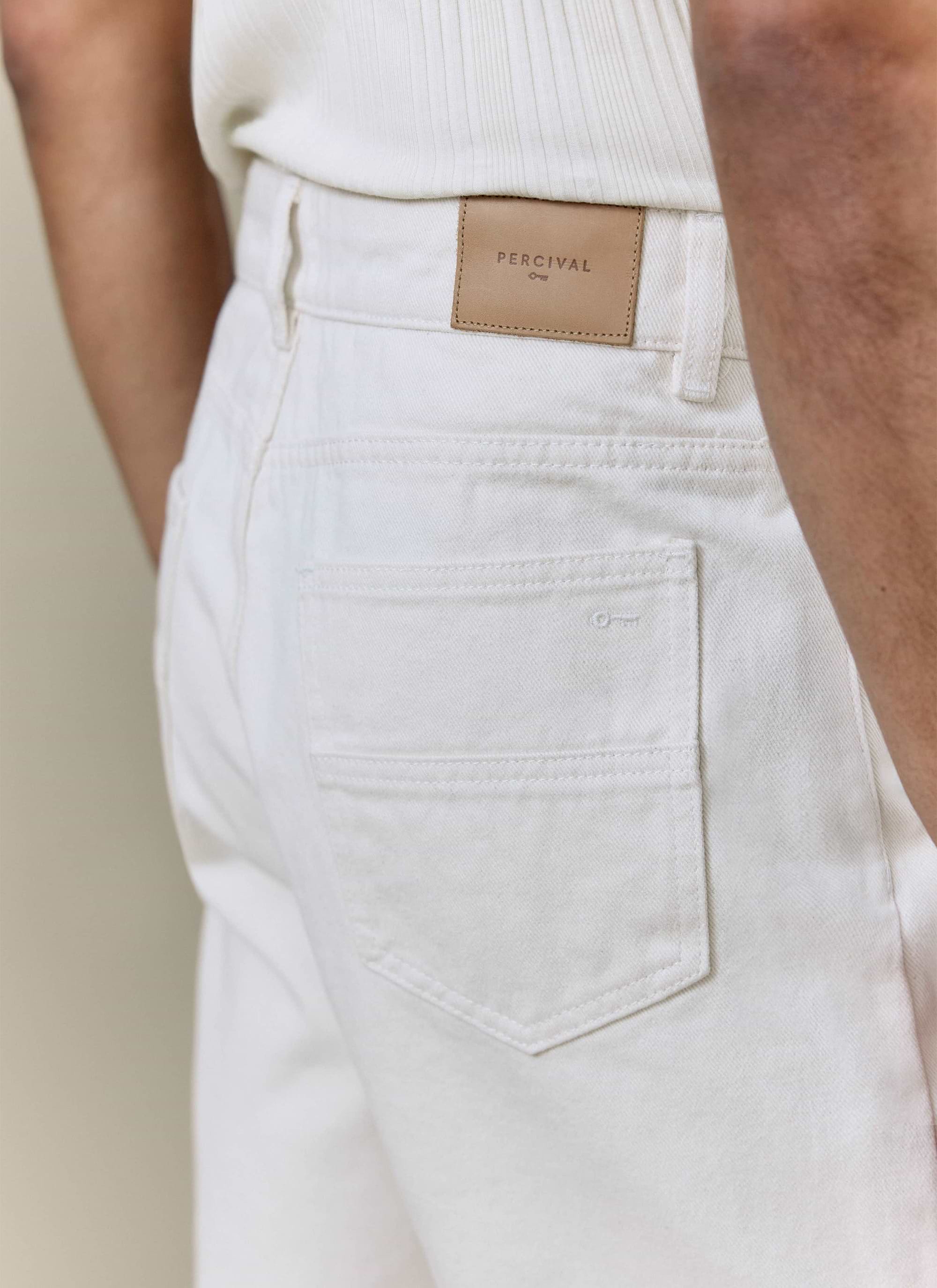 Close-up of the tan leather waistband patch on Percival's cream cotton straight leg denim jeans with pocket detail.