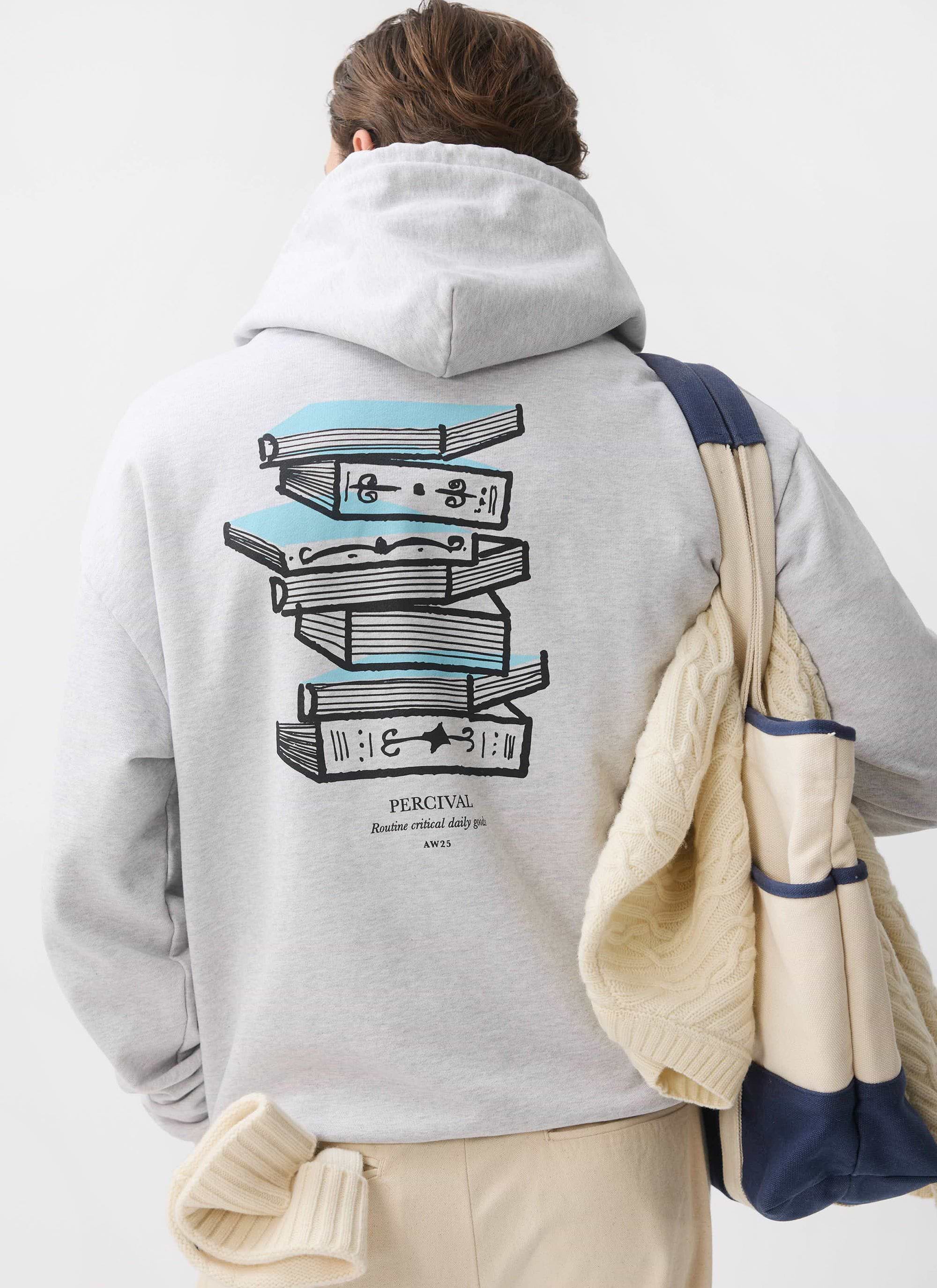 A model viewed from behind wears the grey Percival Duke Hoodie, showing the 'Routine Critical Daily Goods' book graphic.