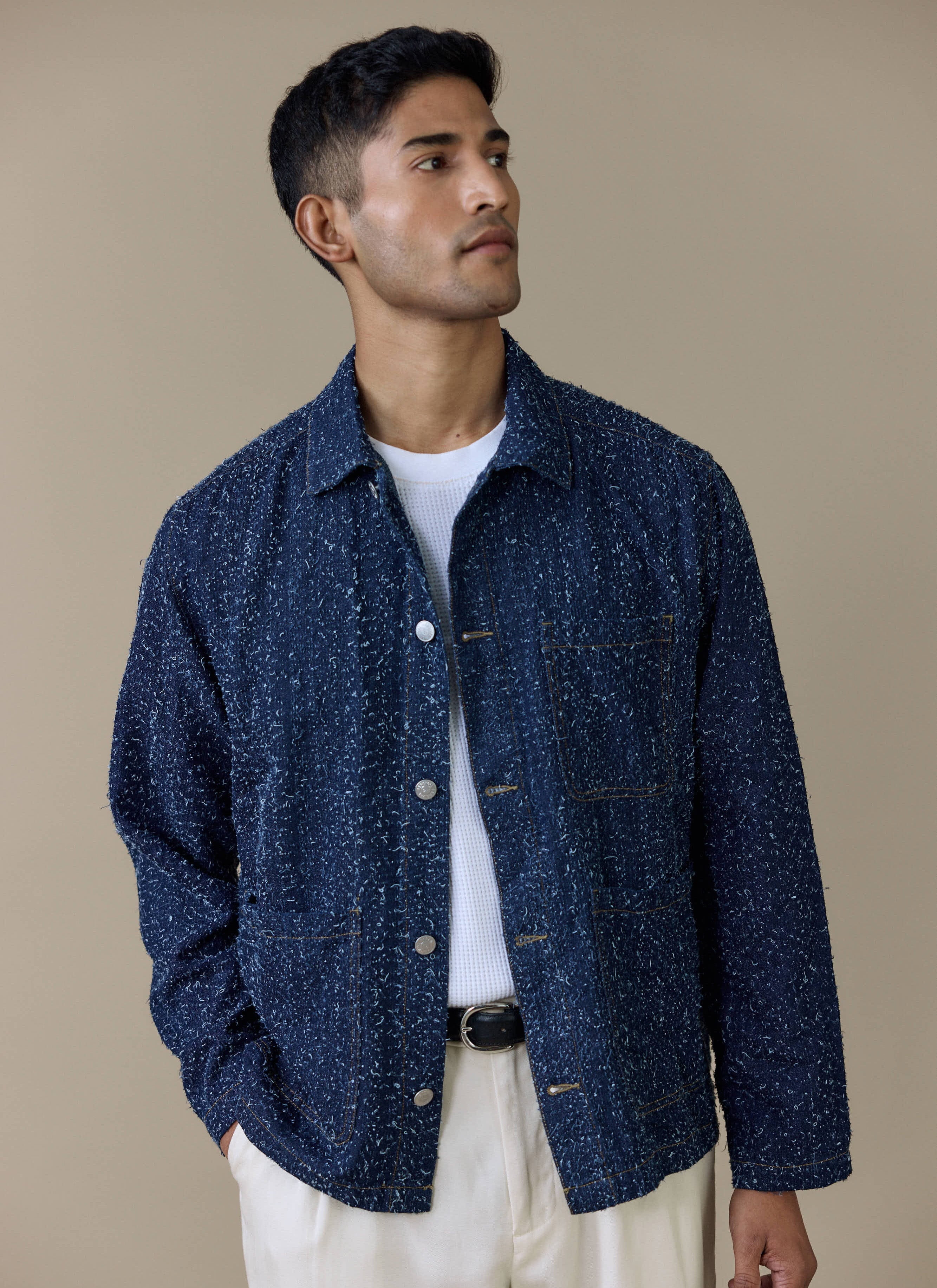 A model wearing the navy Parsons Chore Jacket by Percival, showing the textured cotton and press-stud fastening.