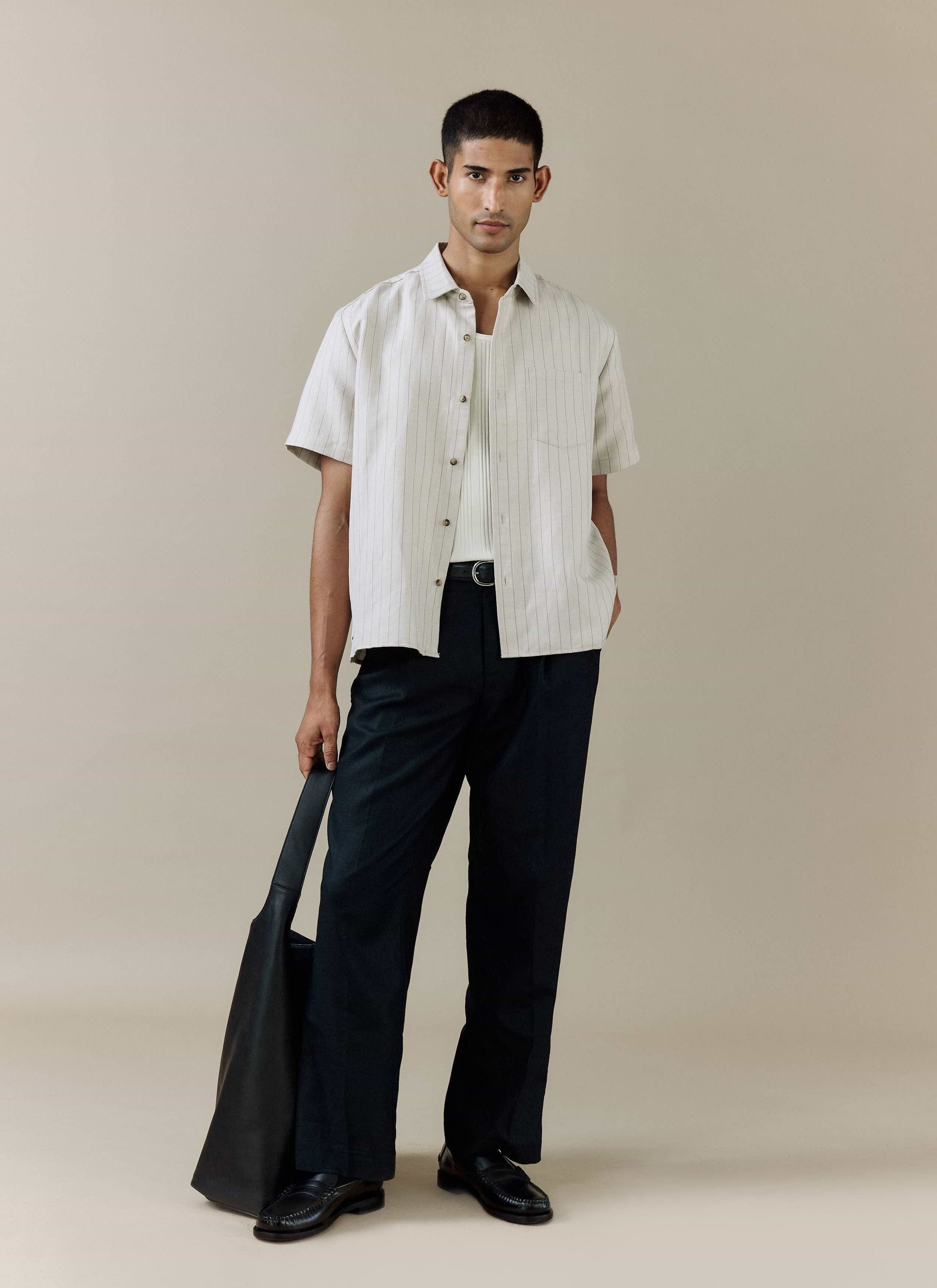 Percival cream pinstripe linen blend Striped Boxy Shirt, styled with navy trousers and a black leather tote bag.