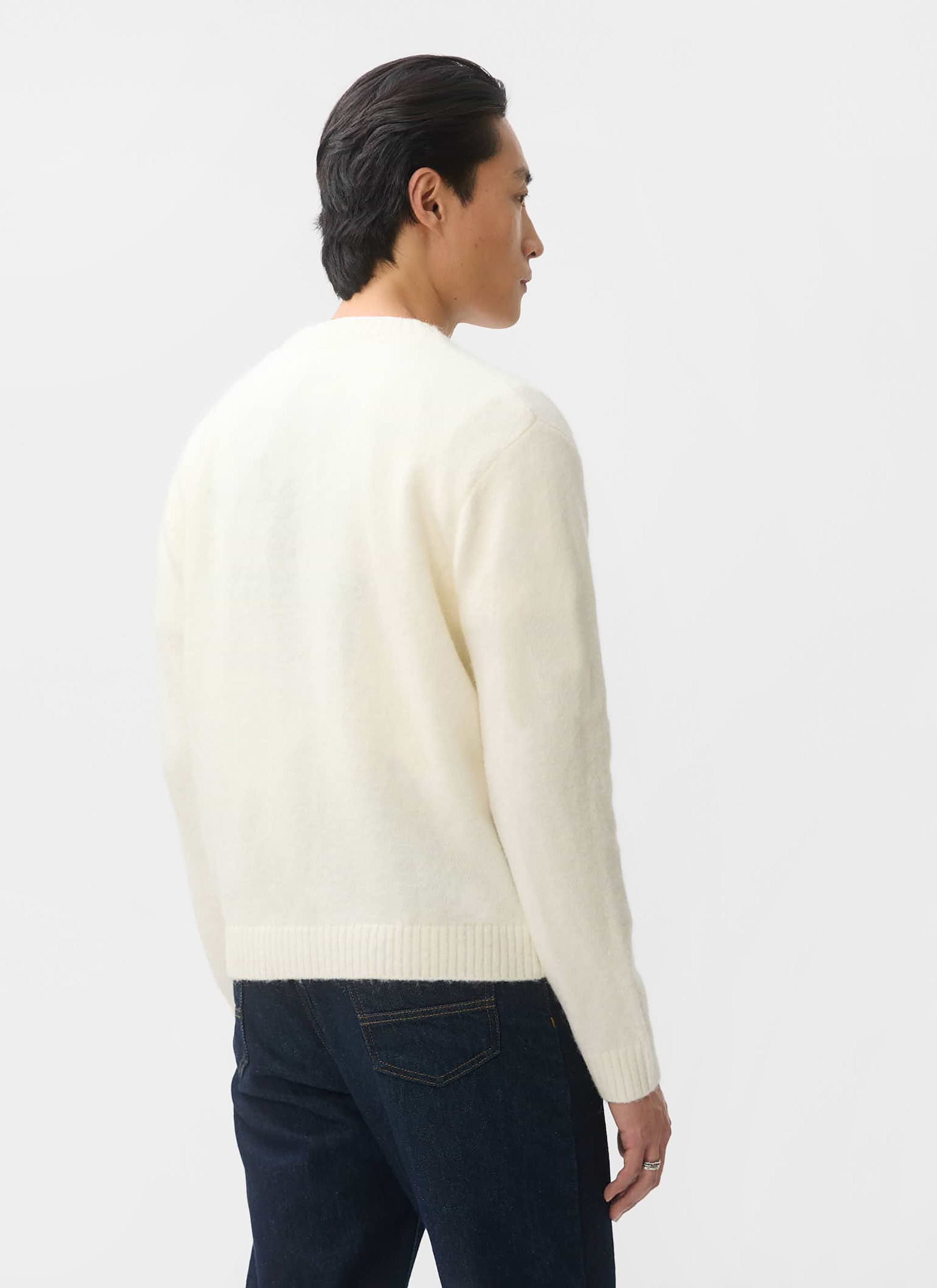 Back view of a model wearing the ecru White Glove Mohair Cardigan from Percival with dark jeans.