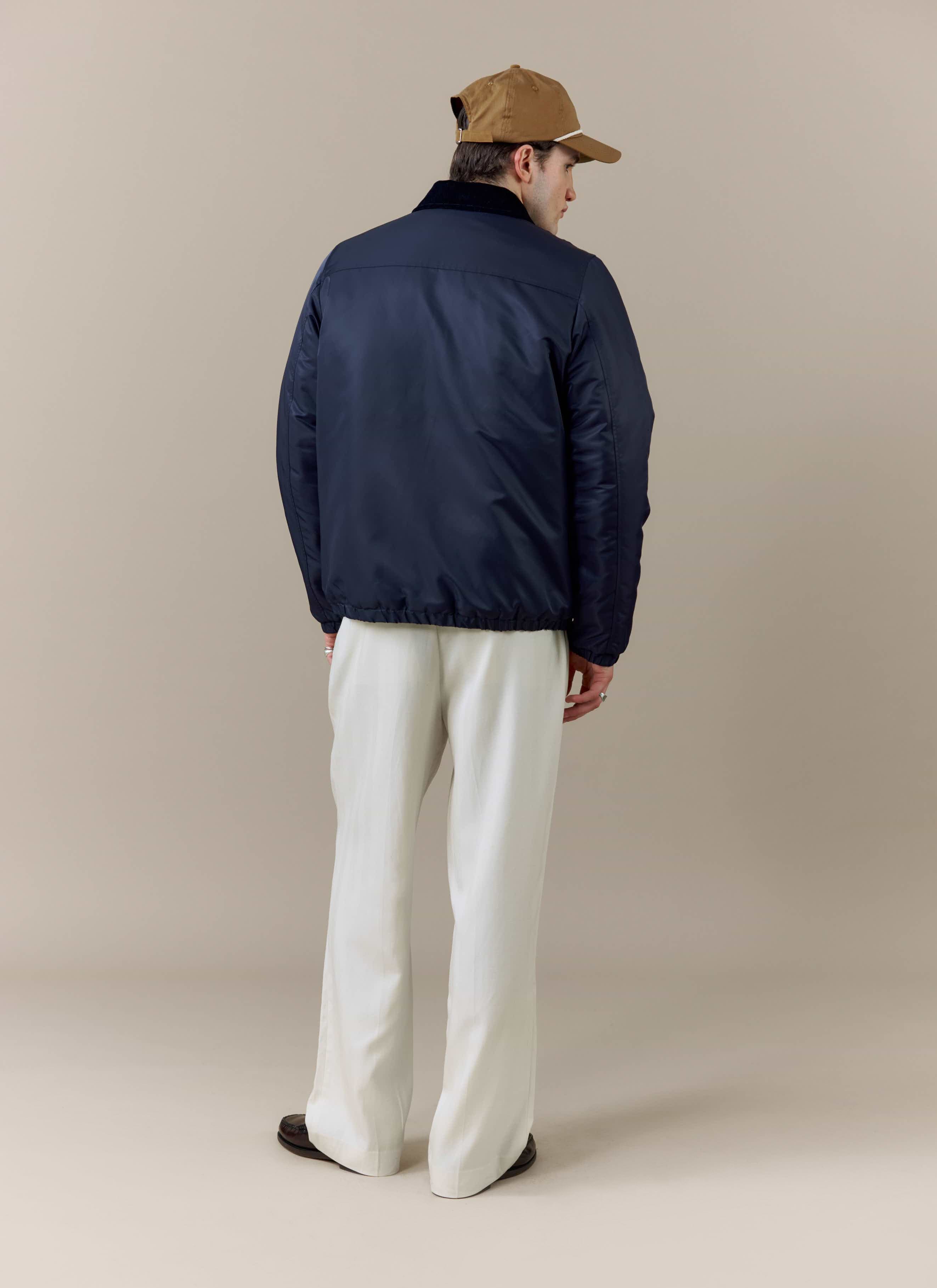 Back view of a model styled in the navy Coach Jacket from the Percival x Brighton & Hove Albion F.C. collaboration.