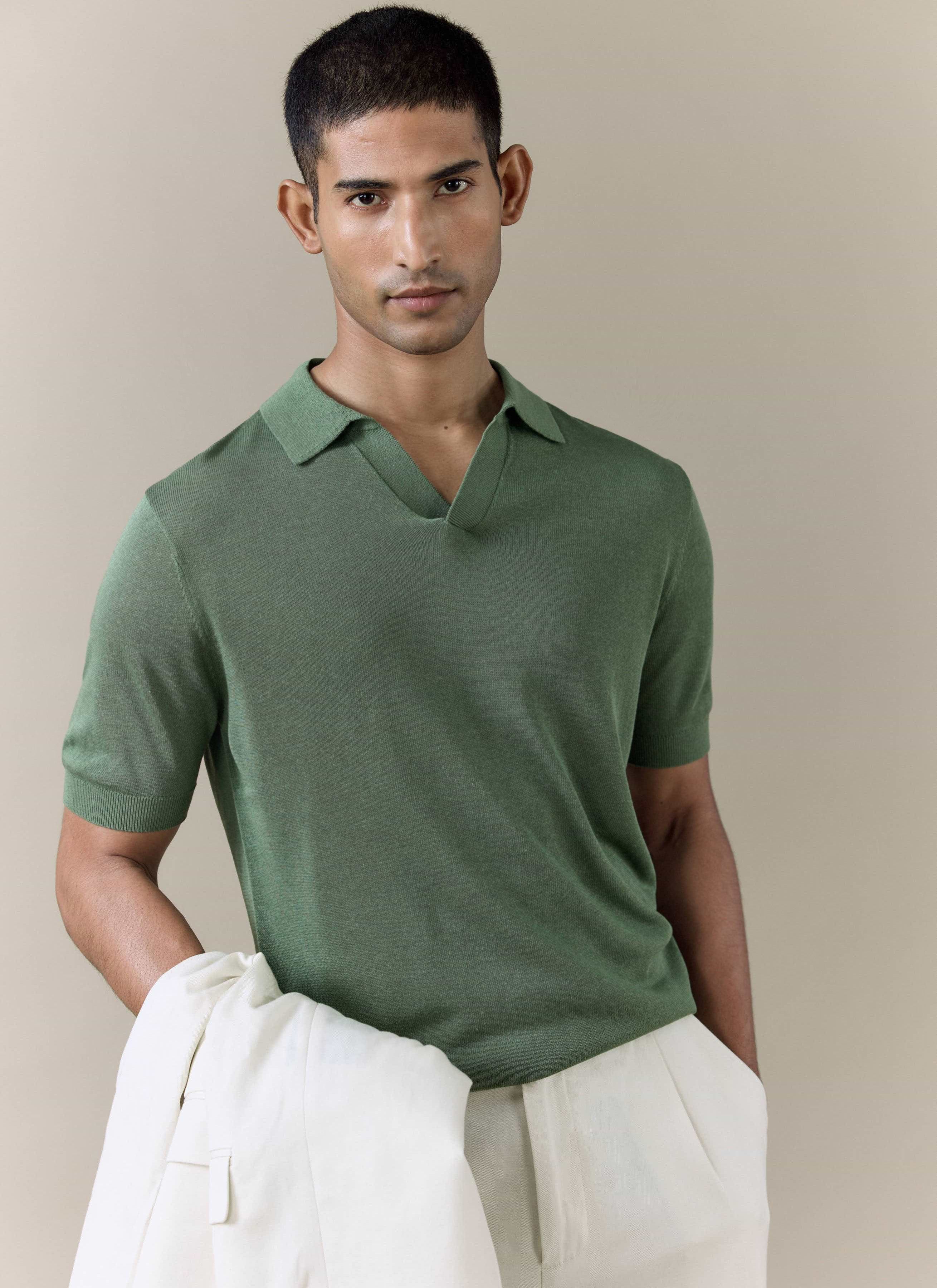 Model wearing the forest green Percival Laurence knitted polo, a breathable linen blend piece with an open V collar.