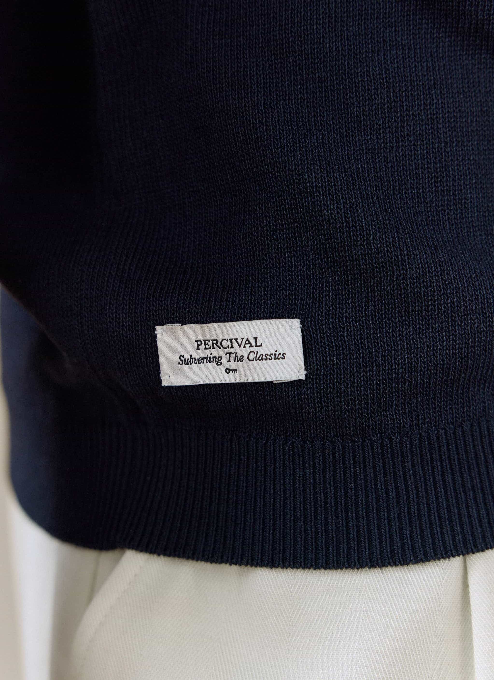 Close-up of the navy linen-lyocell Percival Laurence Knitted Polo hem, showing the Subverting The Classics label.