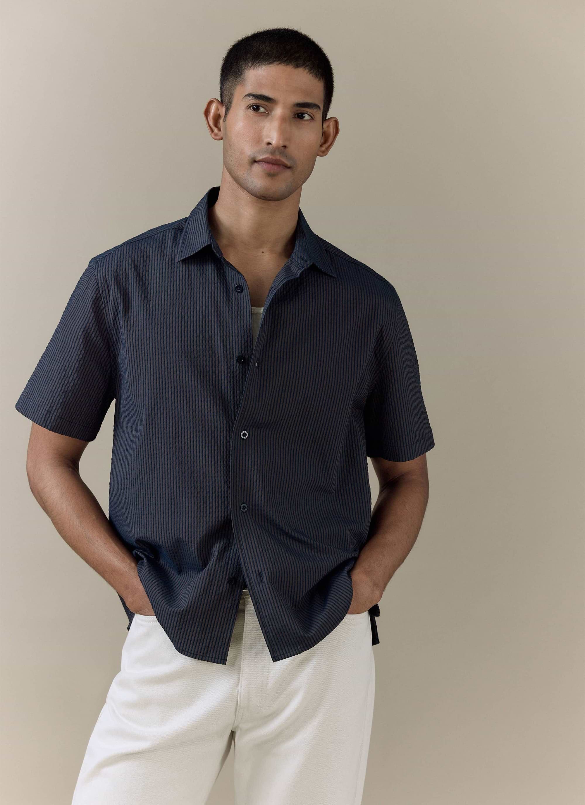 Percival Rowan Seersucker Boxy Shirt in navy stripe, featuring a textured cotton fabric and styled with white trousers.
