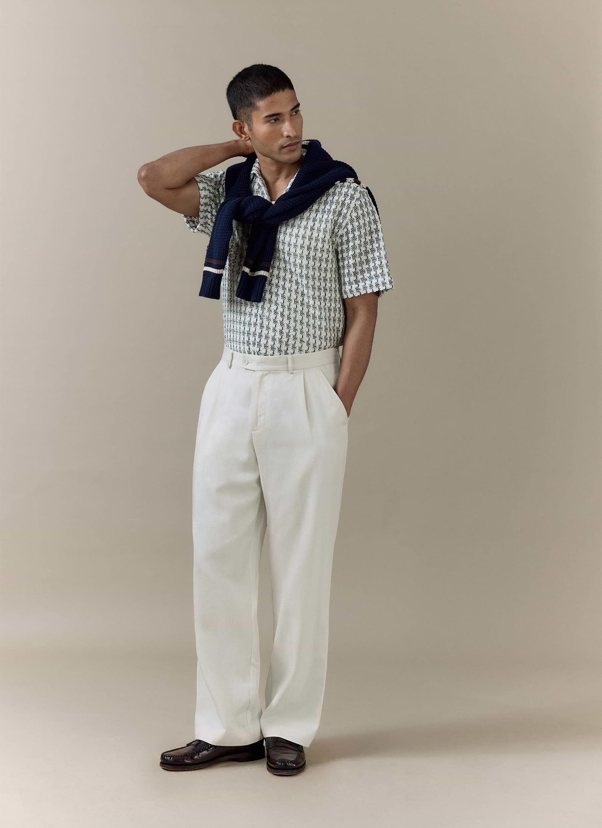 Percival Freddie Crochet Boxy Shirt in green cotton, styled with cream trousers and a navy knit over the shoulders.