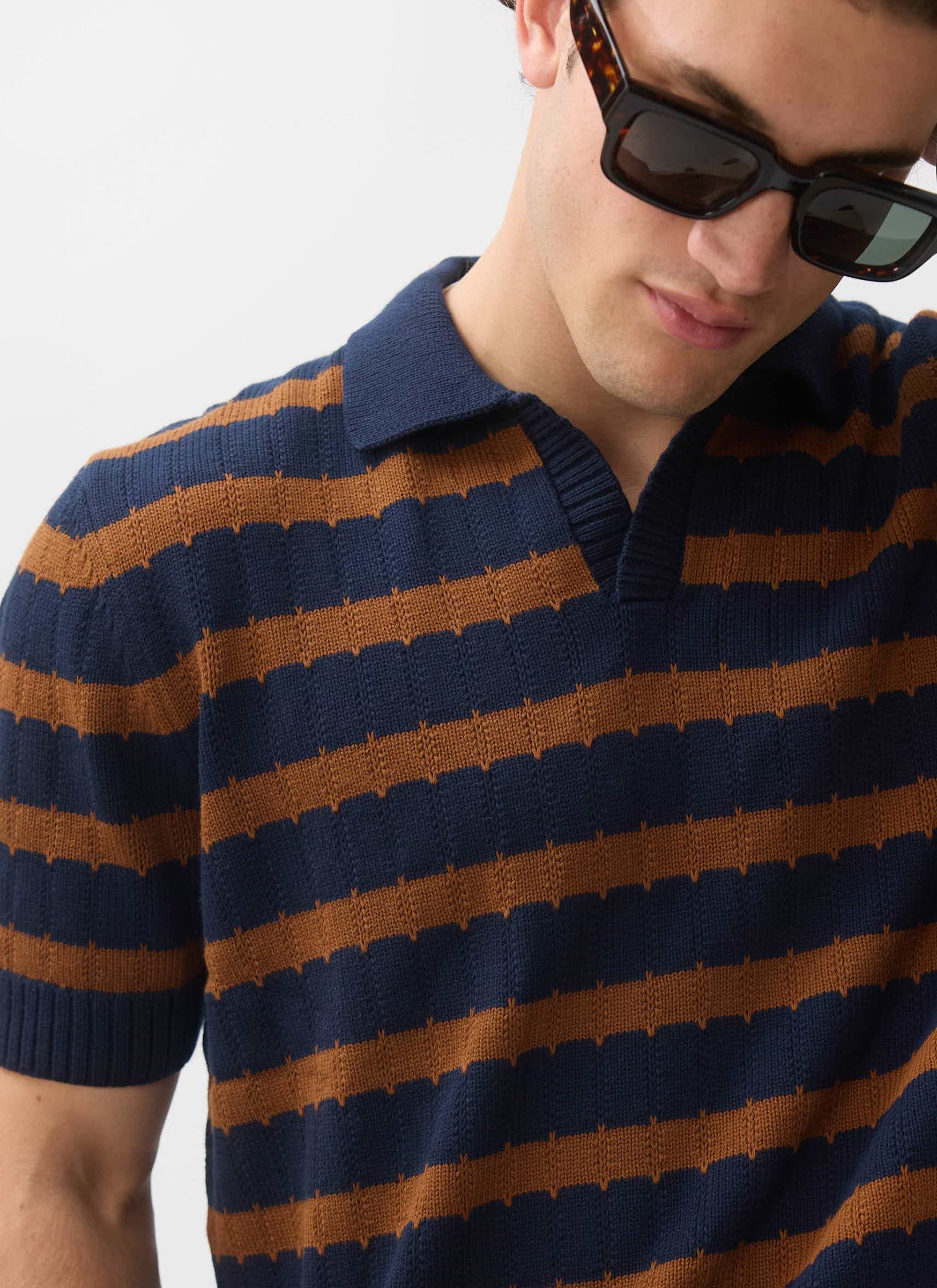 Close-up of a model wearing the Percival Stine Knitted Polo, showing the detail of the brown and navy jacquard stripe.