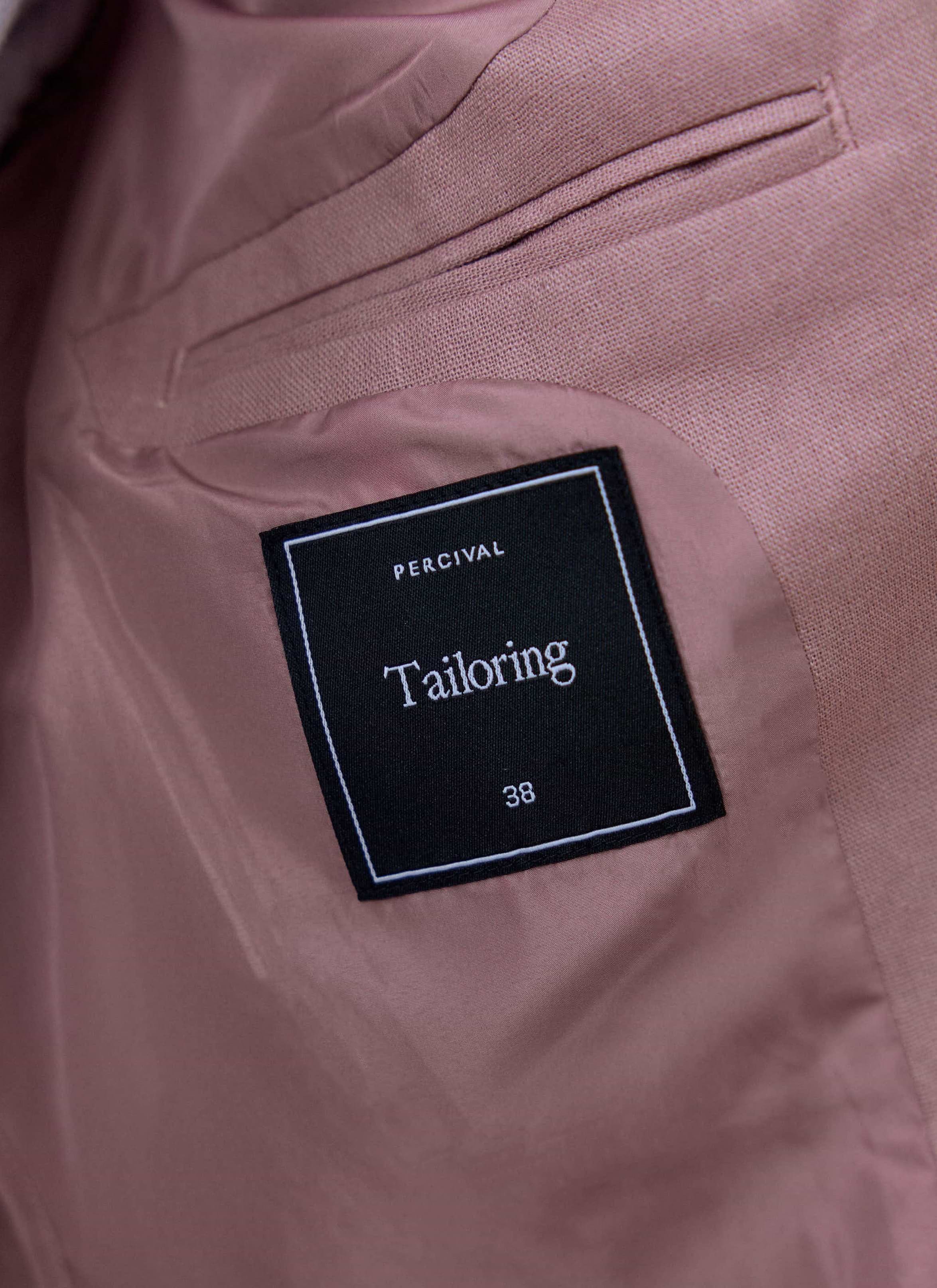 Internal black 'Tailoring' label and size tag on the dusty pink lining of the Percival linen blazer.