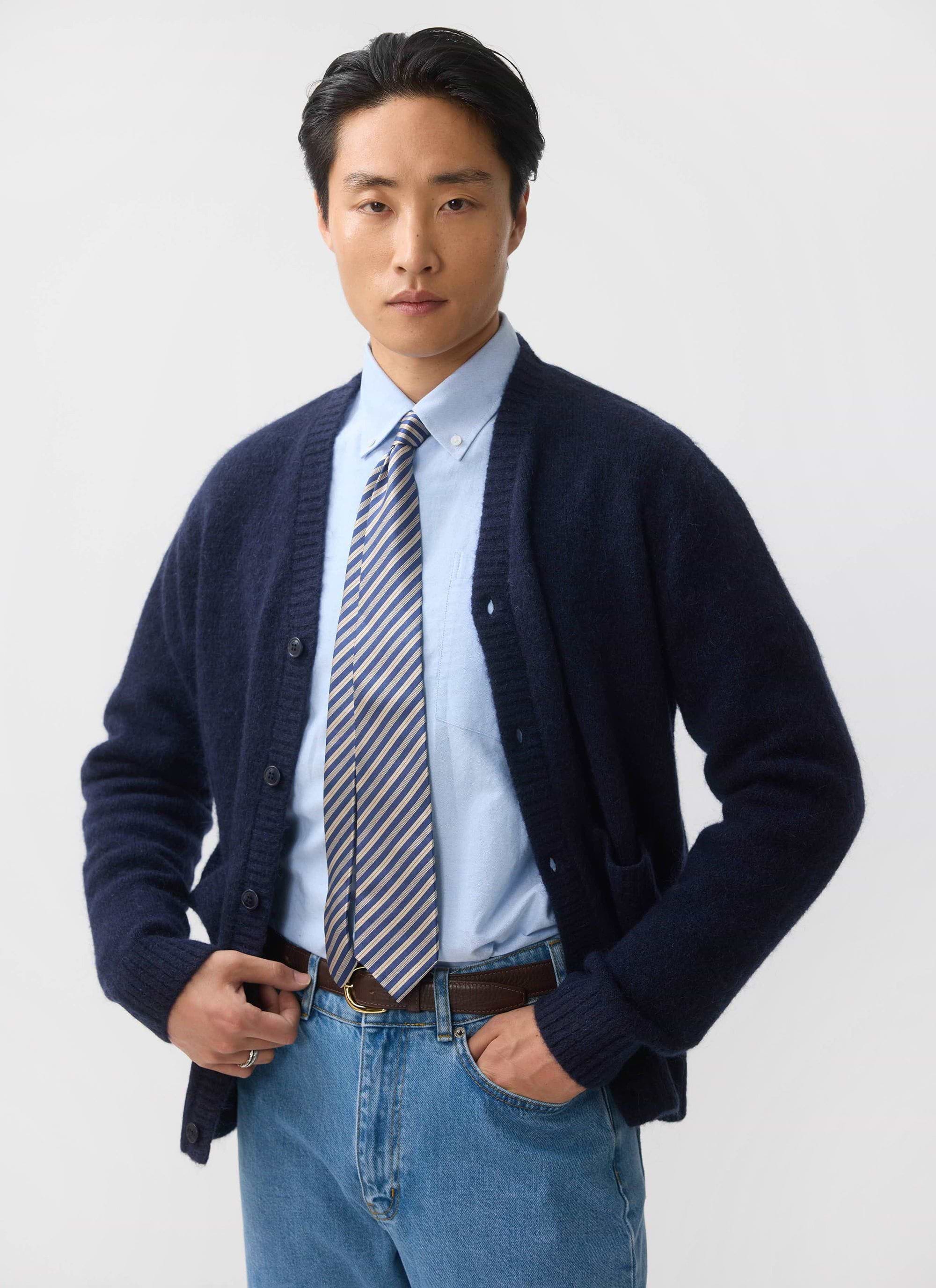 A model styles the Percival White Glove Cardigan in navy mohair, layered over a light blue shirt and striped tie.