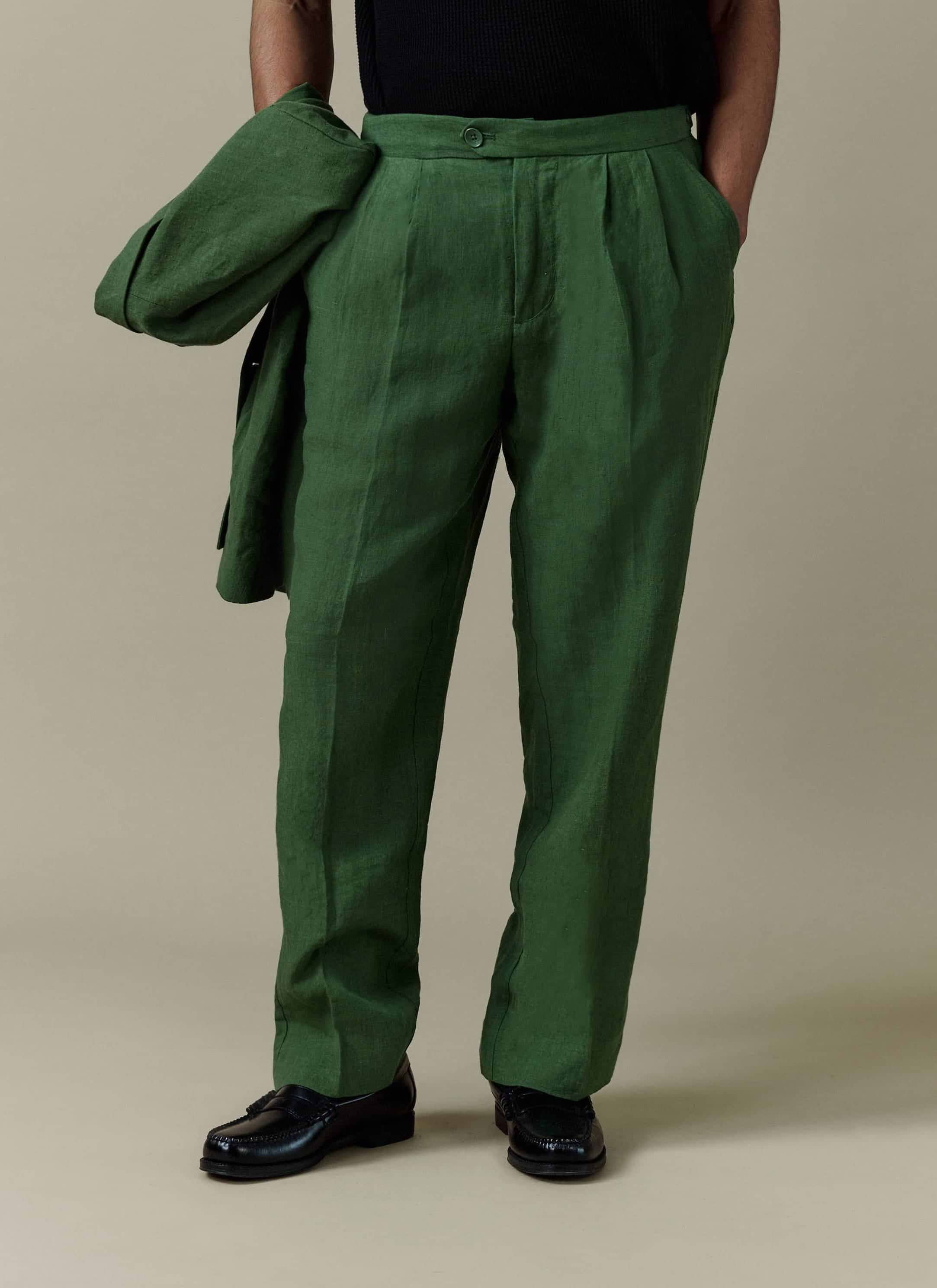 Forest green linen pleated tailored trousers by Percival, featuring a relaxed fit and double pleat details.