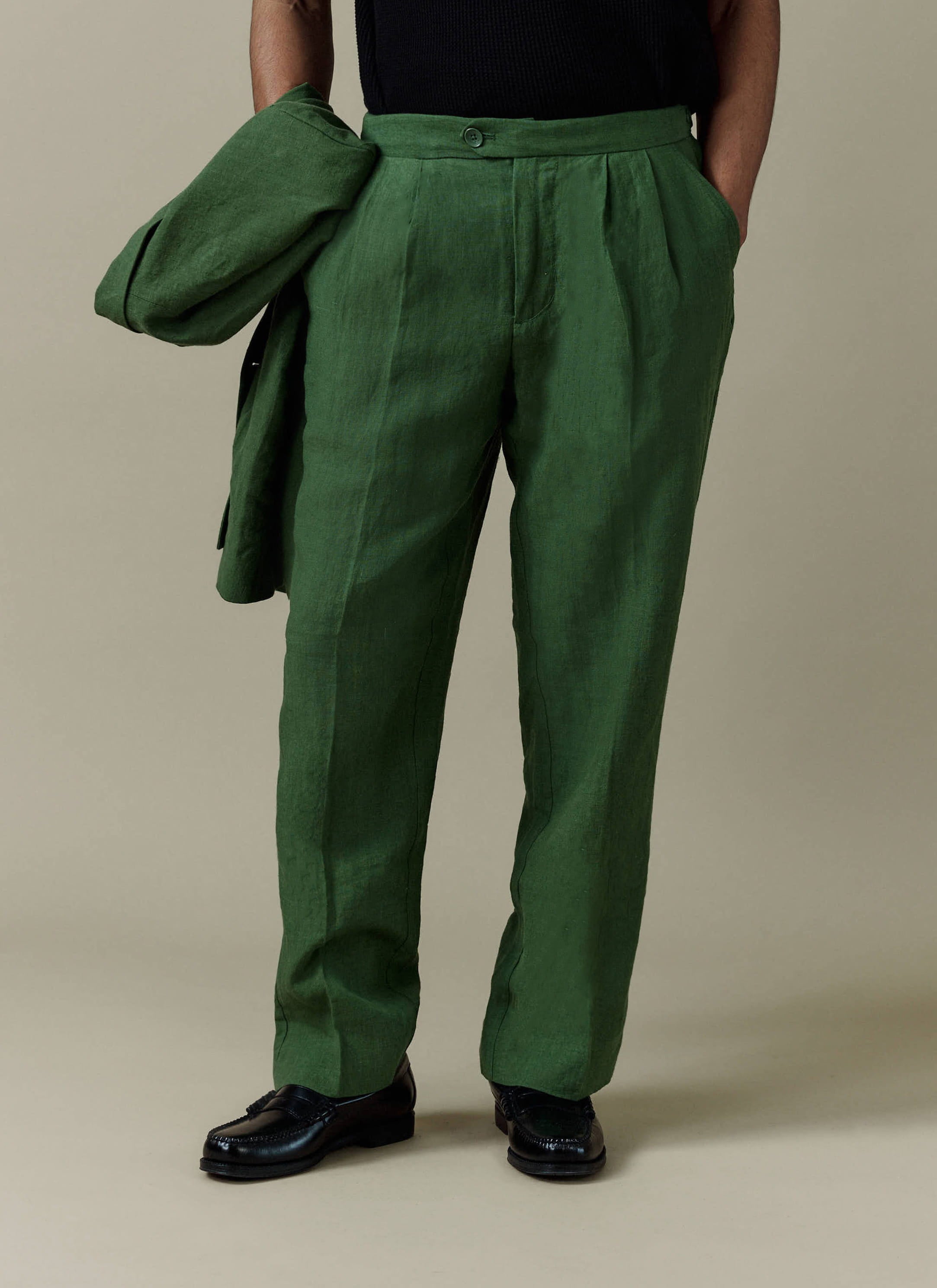 Forest green linen pleated tailored trousers by Percival, featuring a relaxed fit and double pleat details.