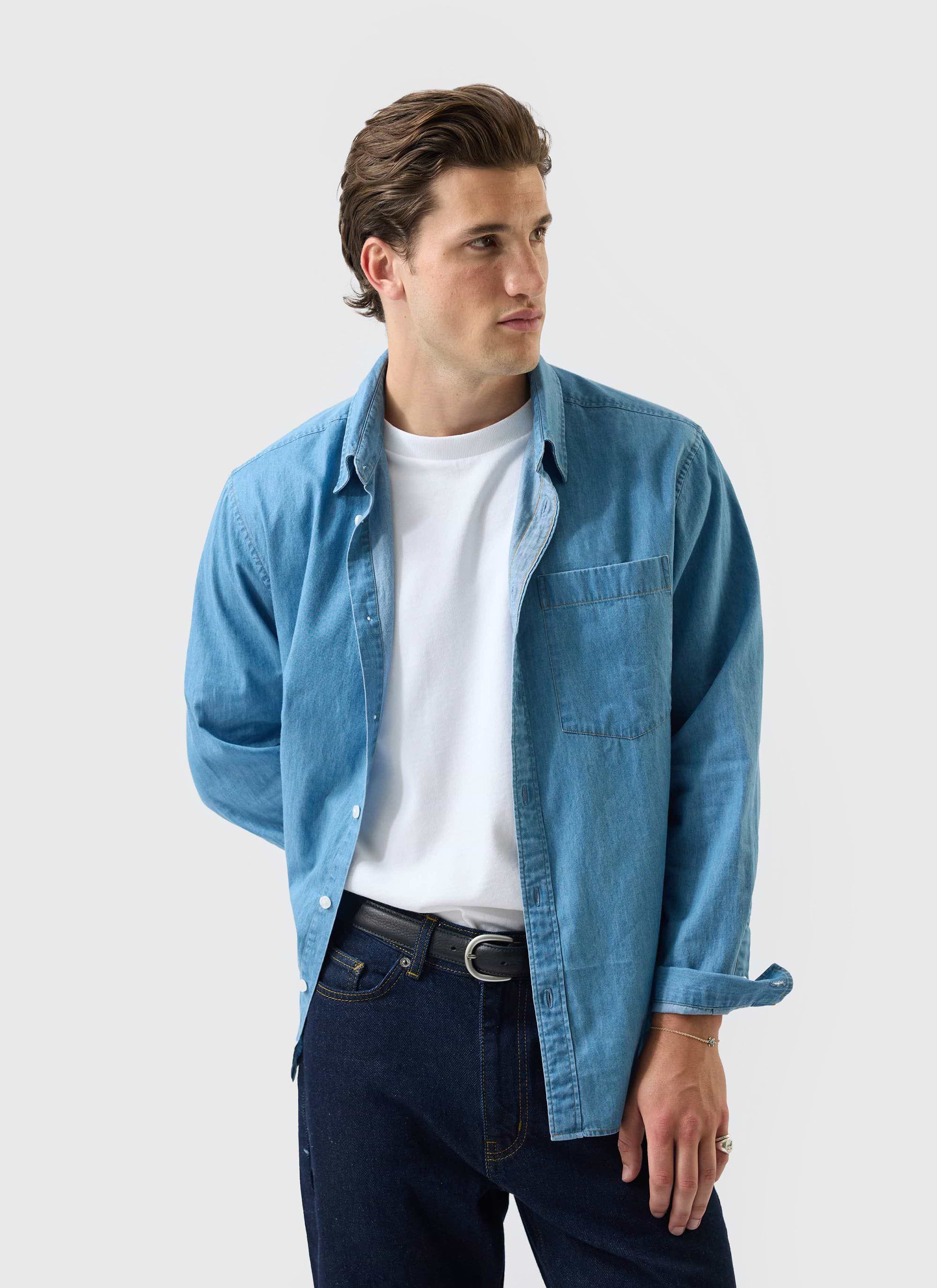 A model wears the Percival Marco Pearce denim shirt in light blue, layered over a white t-shirt and dark jeans.