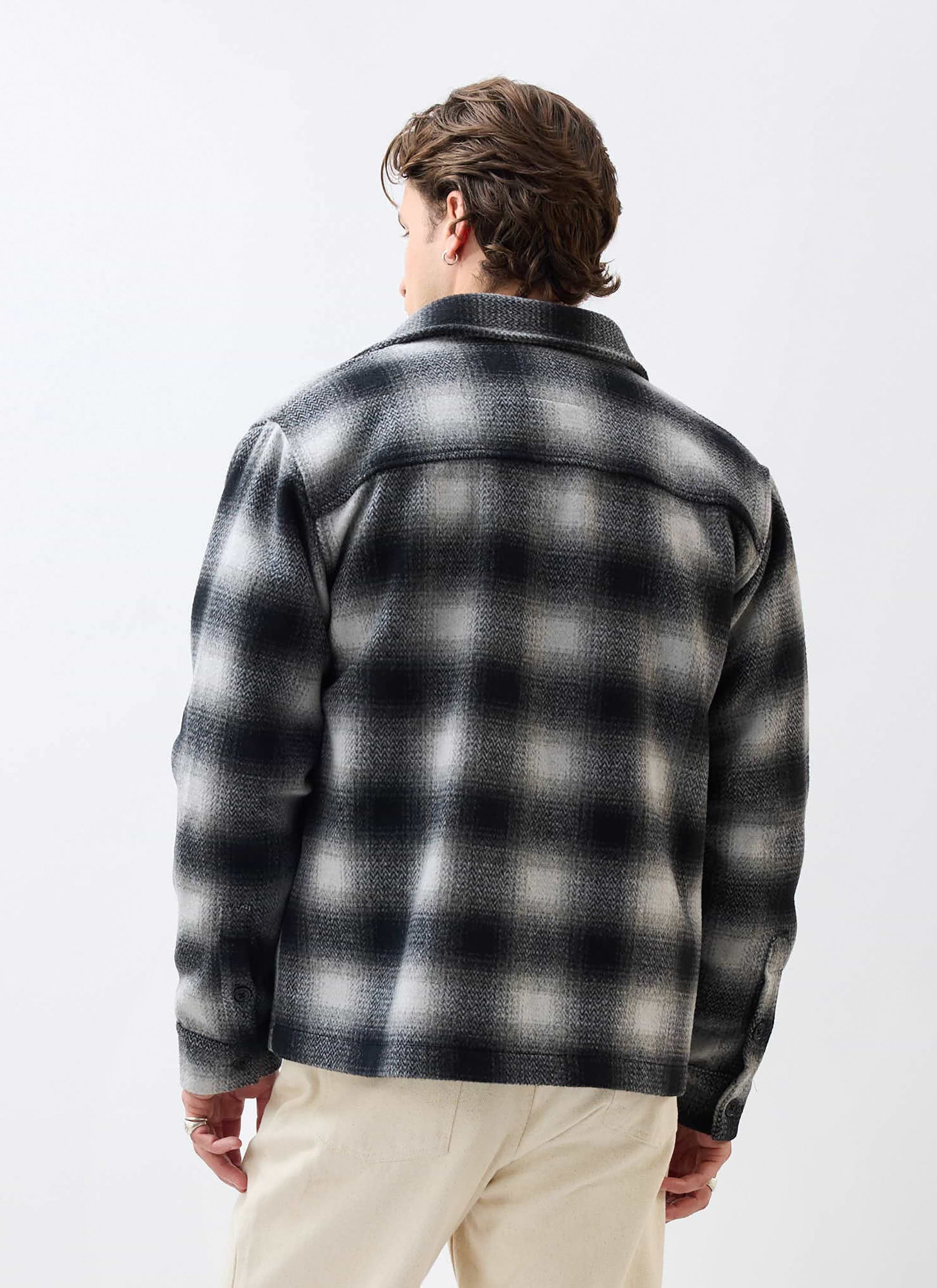 Back view of a model wearing the Percival Check Overshirt in a grey and black wool blend against a white background.