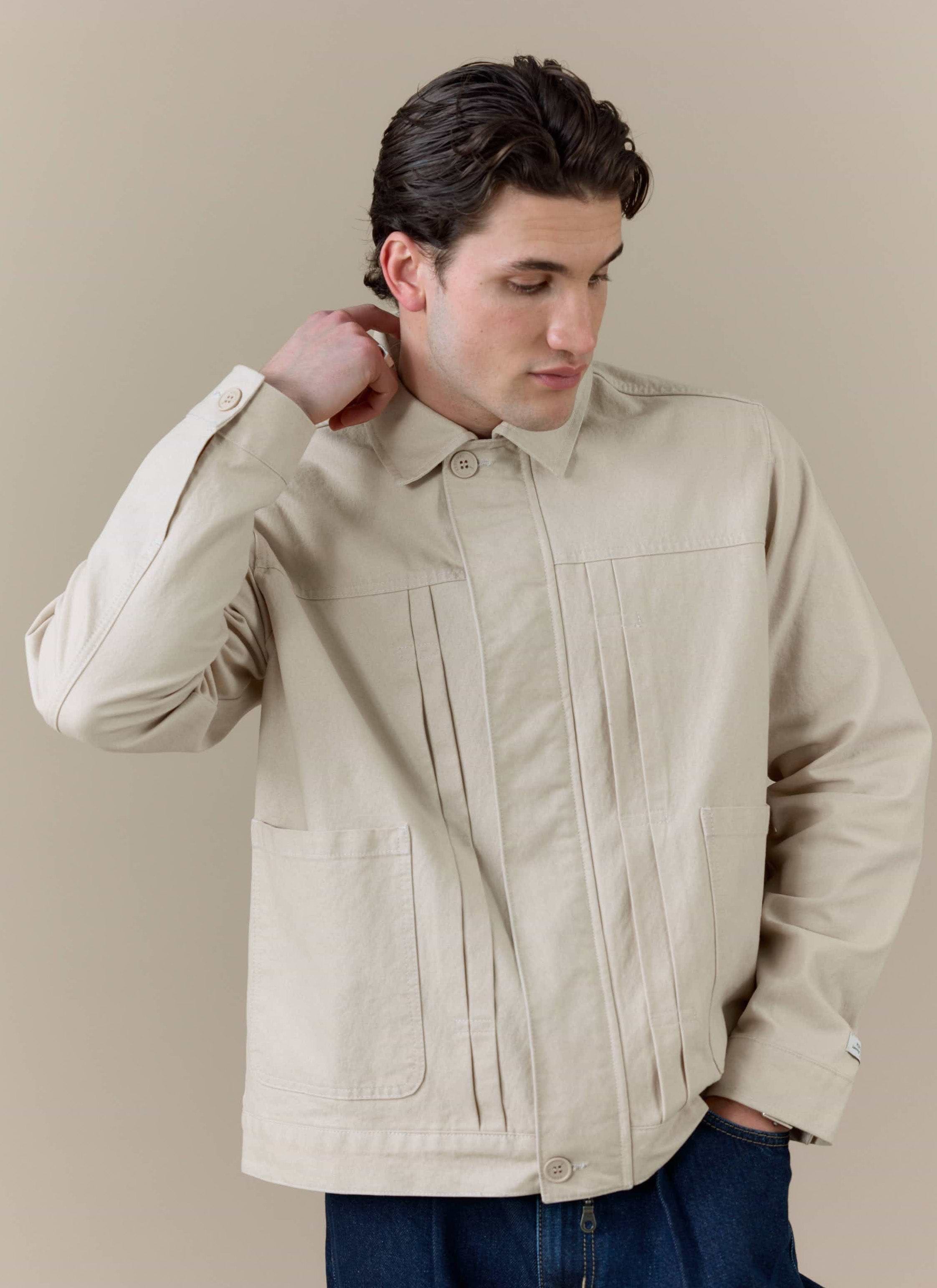 Model wearing the cream Ernst Jacket by Percival, featuring a double pleated front and structured, boxy fit.