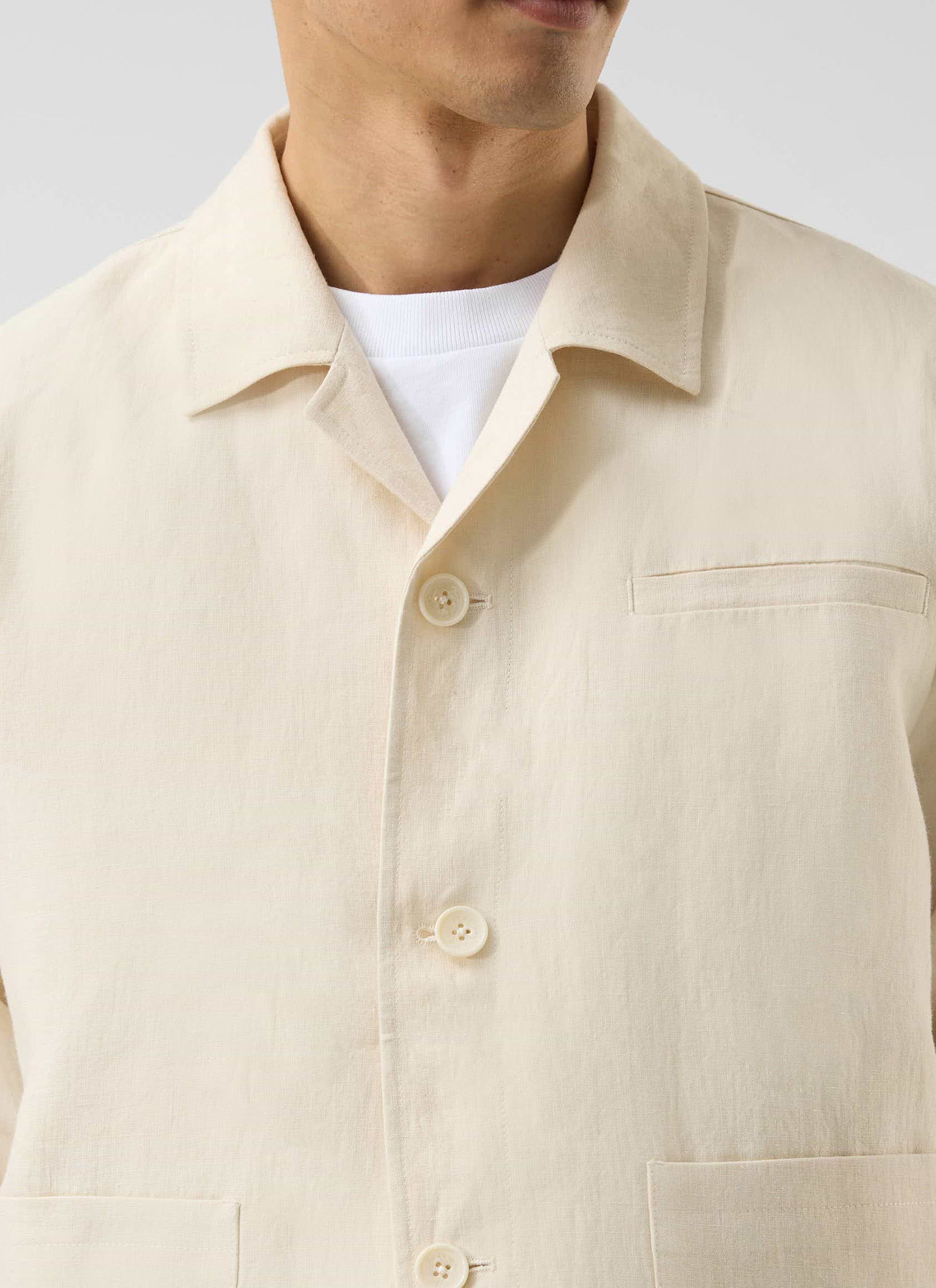 A close-up of a model wearing the stone-coloured Relaxed Linen Overshirt from Percival, showing the collar and buttons.