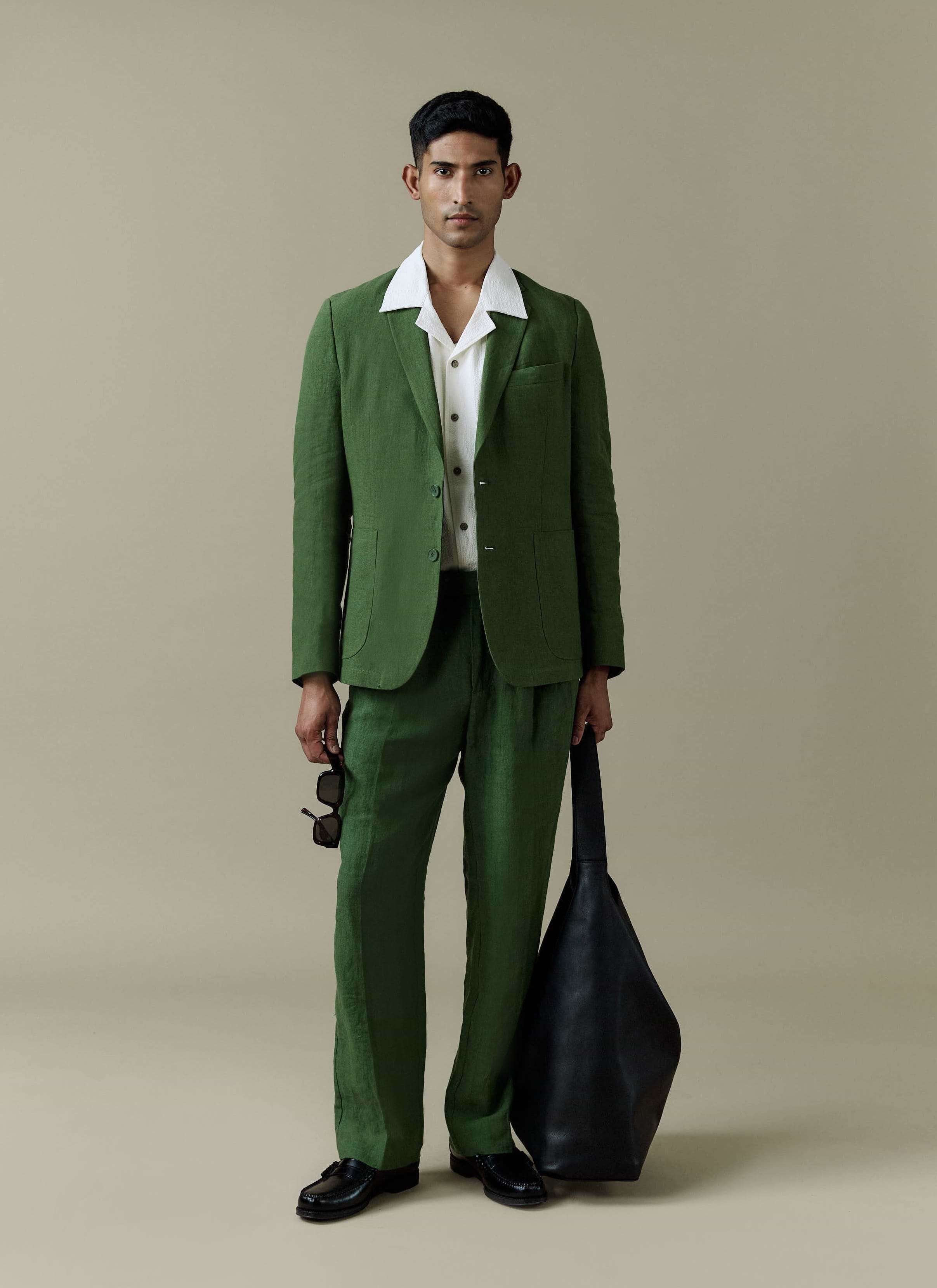 Percival Tailored Linen Blazer and matching trousers in forest green worn by a model with a white textured shirt.