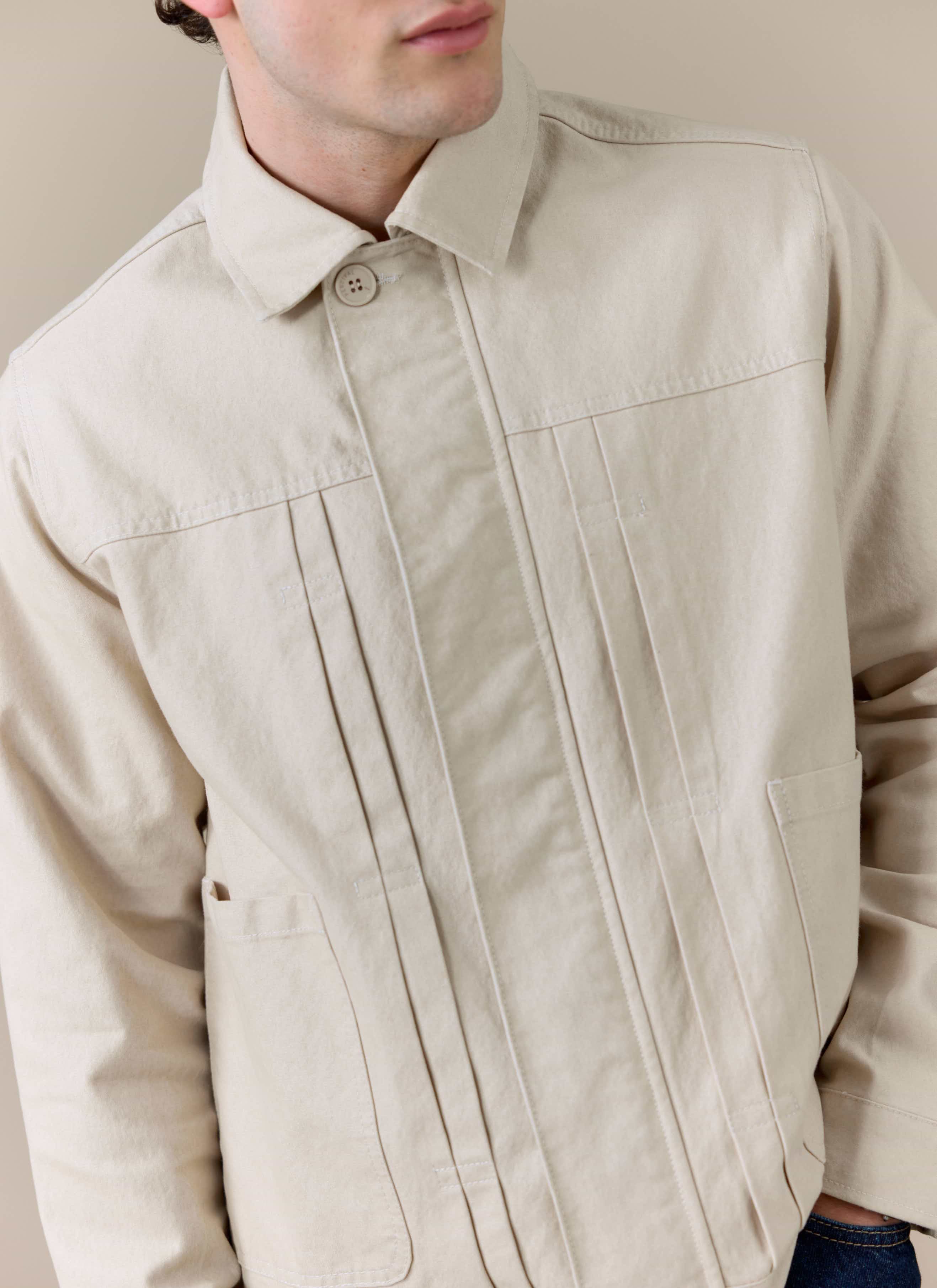 Close-up of the cream Percival Ernst Jacket, showing the structured cotton-blend fabric and double pleated front detail.