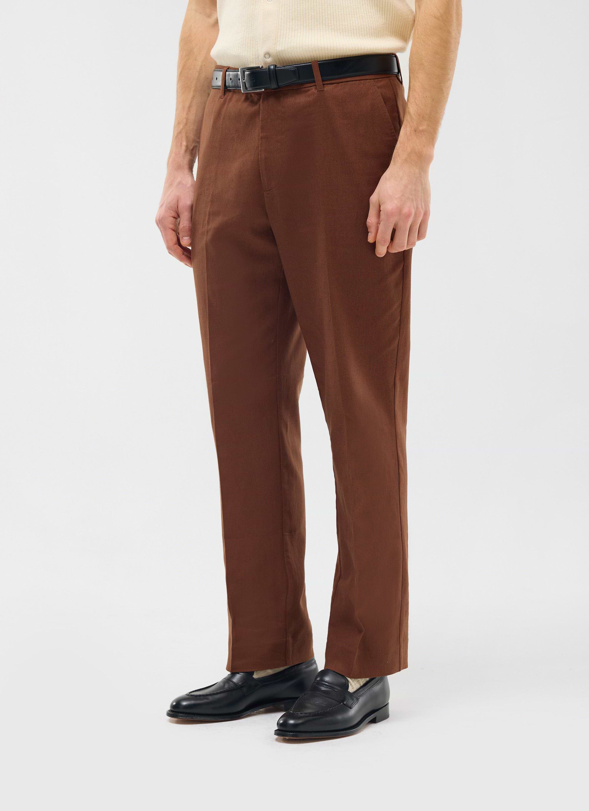 The Percival Tailored Linen Trousers in brown, worn by a model with a black belt and loafers to show the straight leg fit.