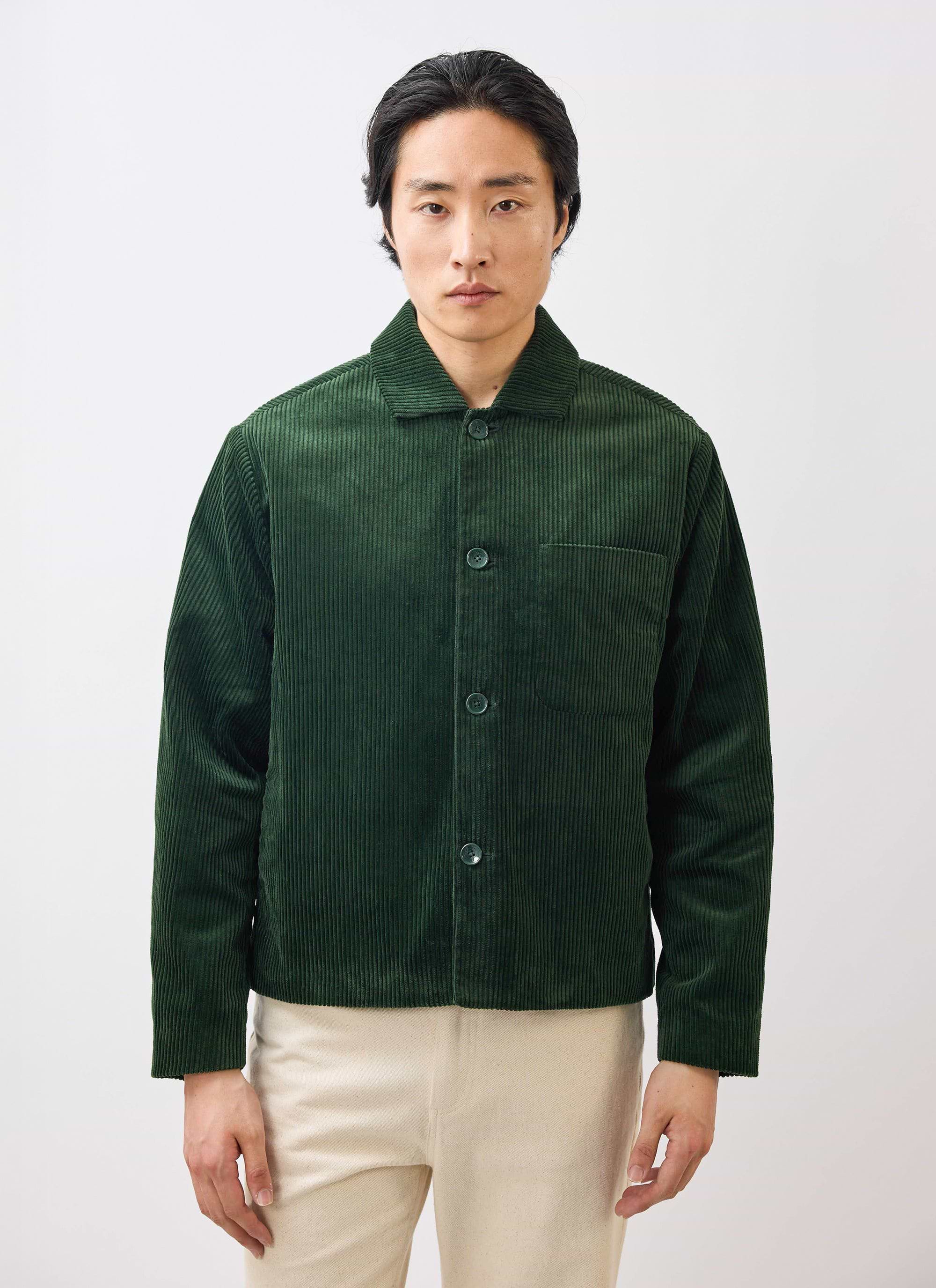 A model wears the Percival Cord Overshirt in forest green corduroy against a white studio background.