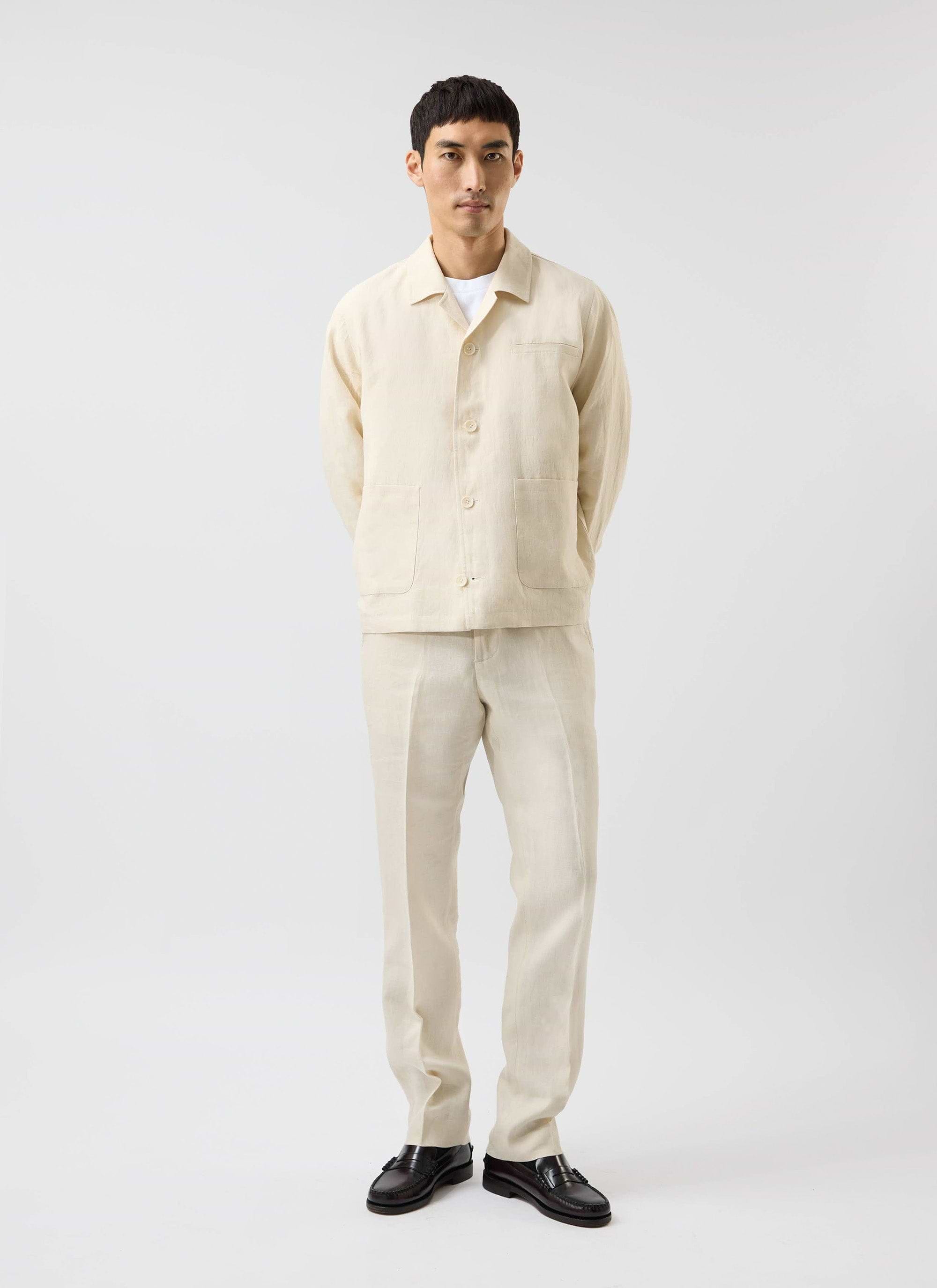 A full-length studio shot of a model wearing the Percival Relaxed Linen Overshirt in stone with matching trousers.