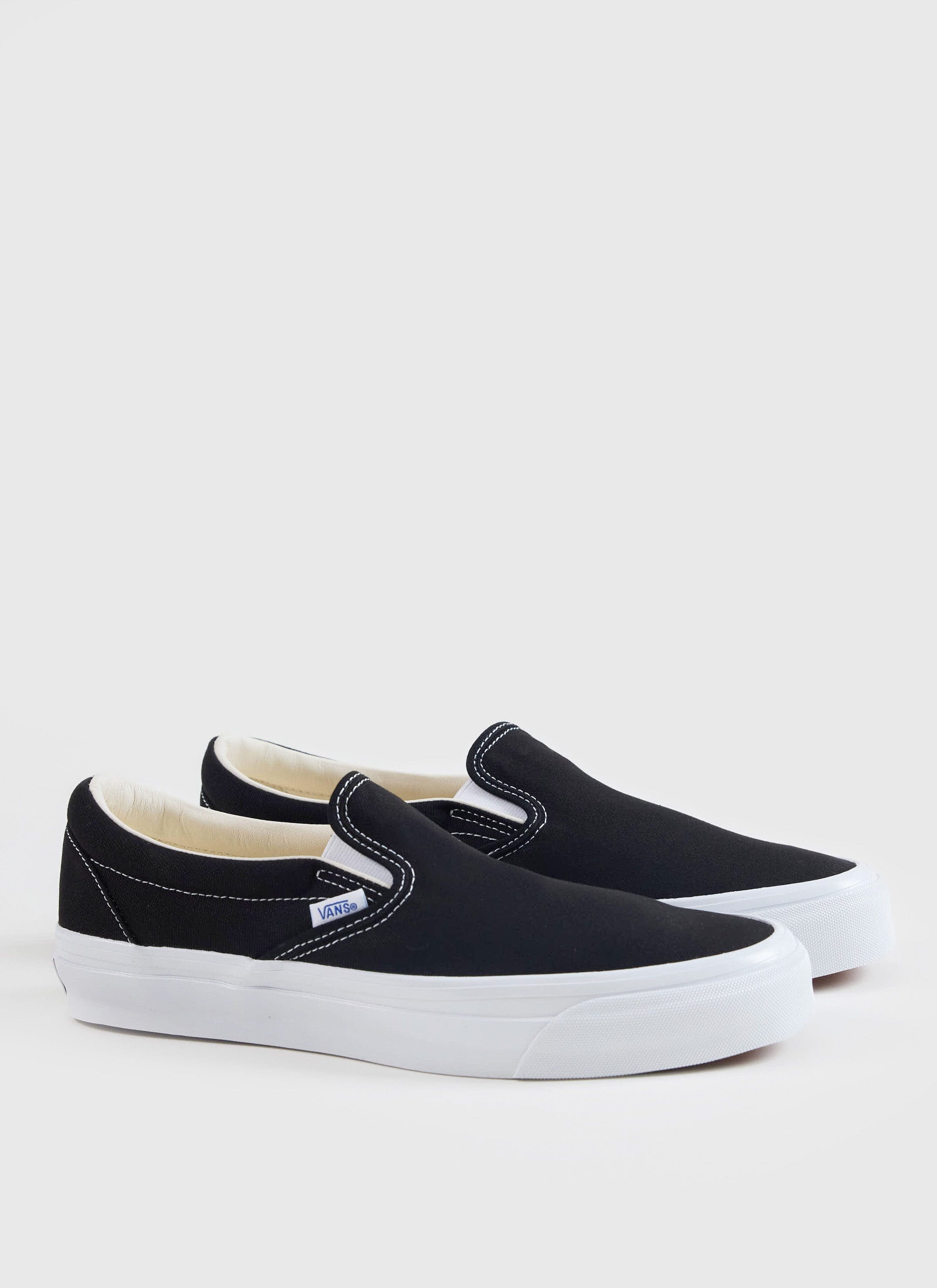 Black Vans Slip-On Reissue 98 shoes with white soles and contrast stitching, available from Percival.