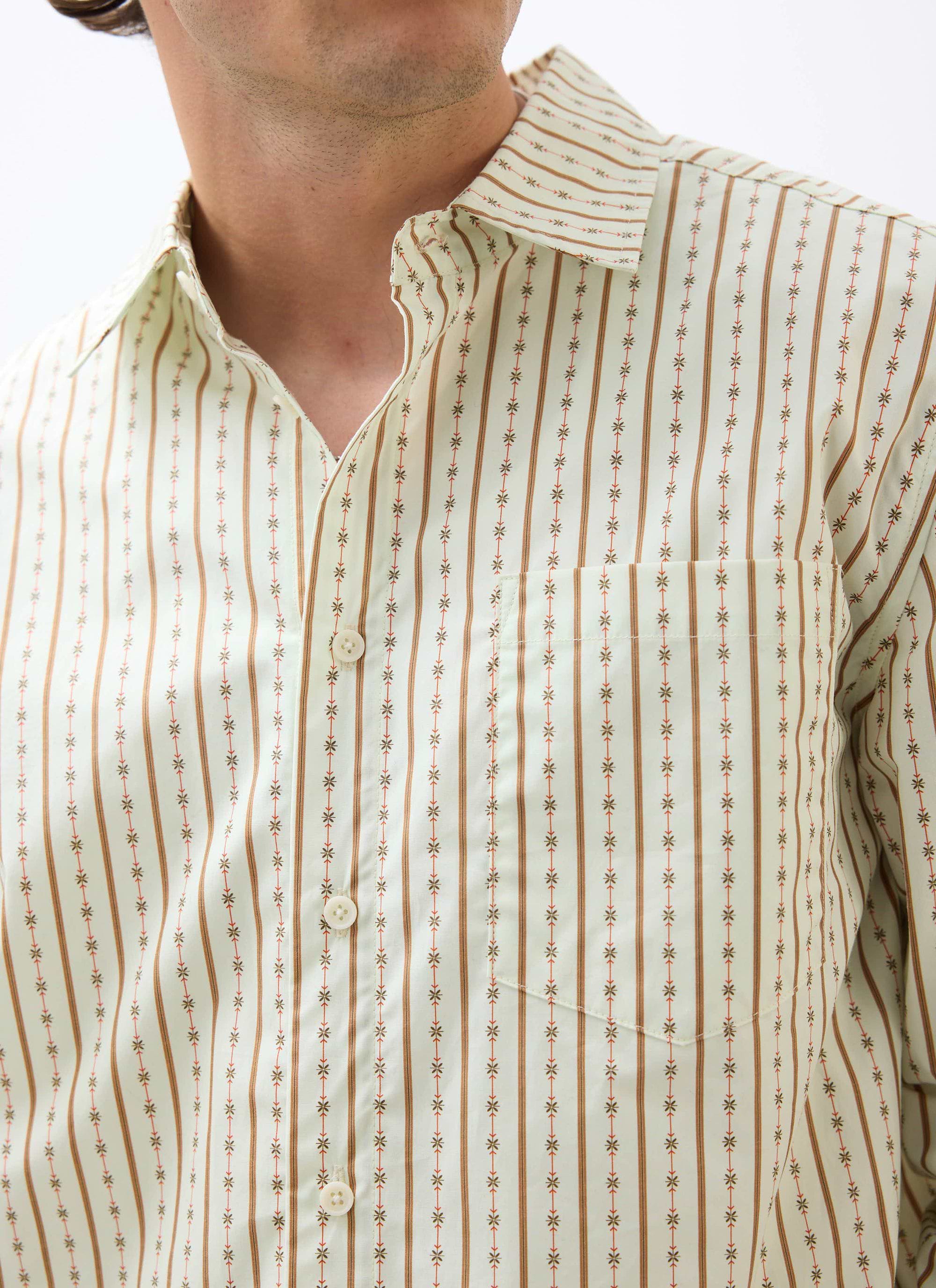 A close-up of a model wearing the ecru Binding Oversized Pearce Shirt by Percival, showing the striped pattern and pocket.