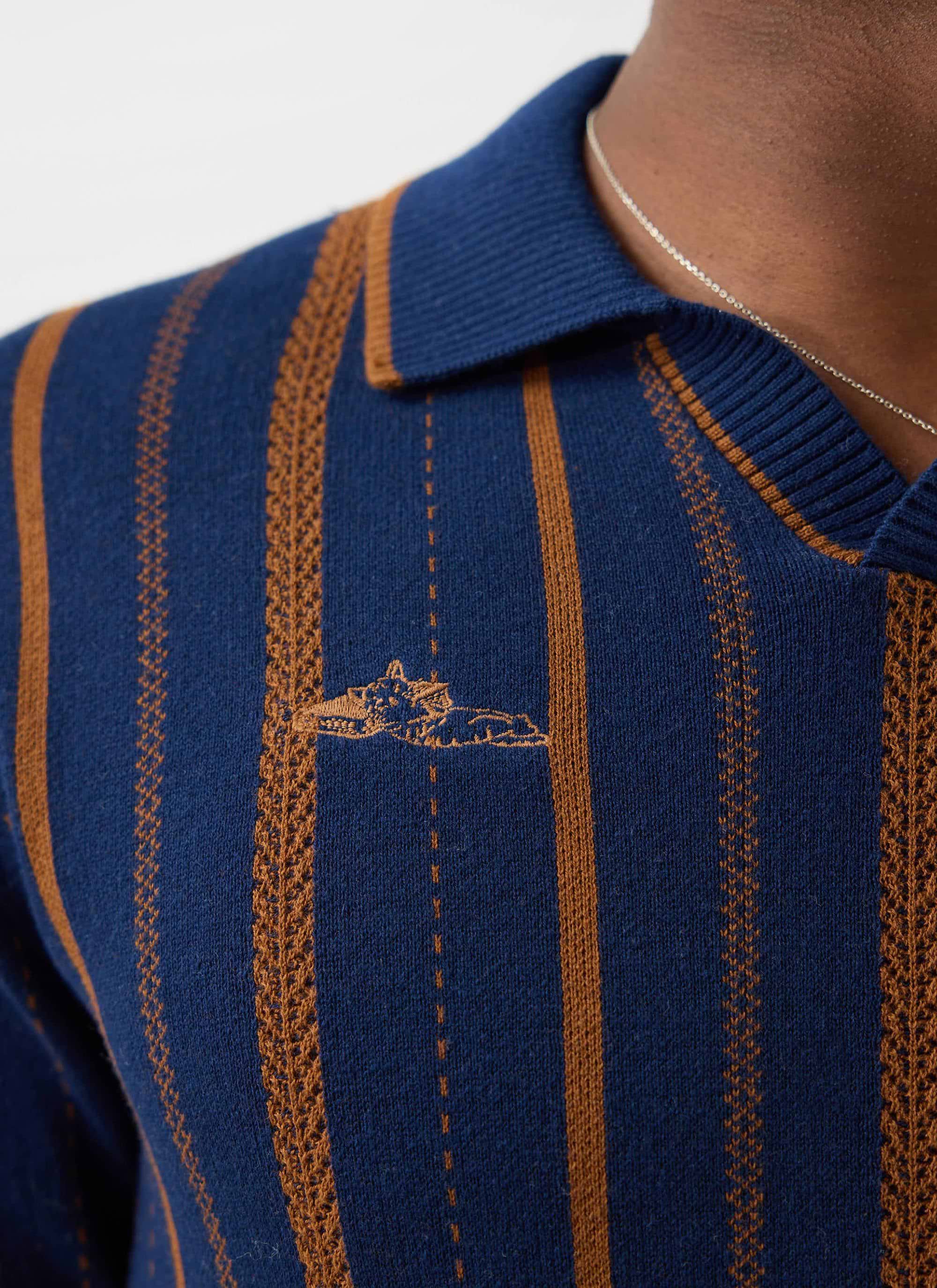Close up of the Percival Citation Knitted Football Shirt, showing the navy and brown striped design and embroidered logo.