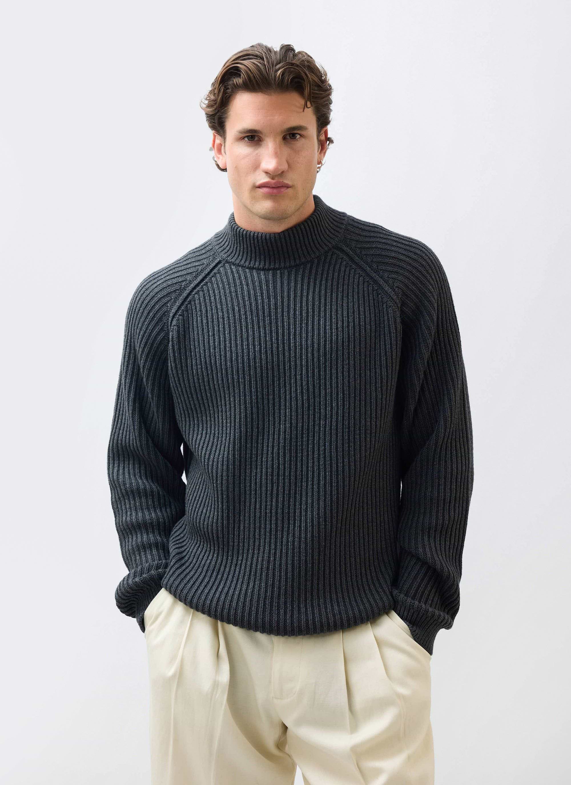 A model wears the Percival Library Turtle Neck in charcoal, a ribbed cotton-wool blend jumper, styled with cream trousers.
