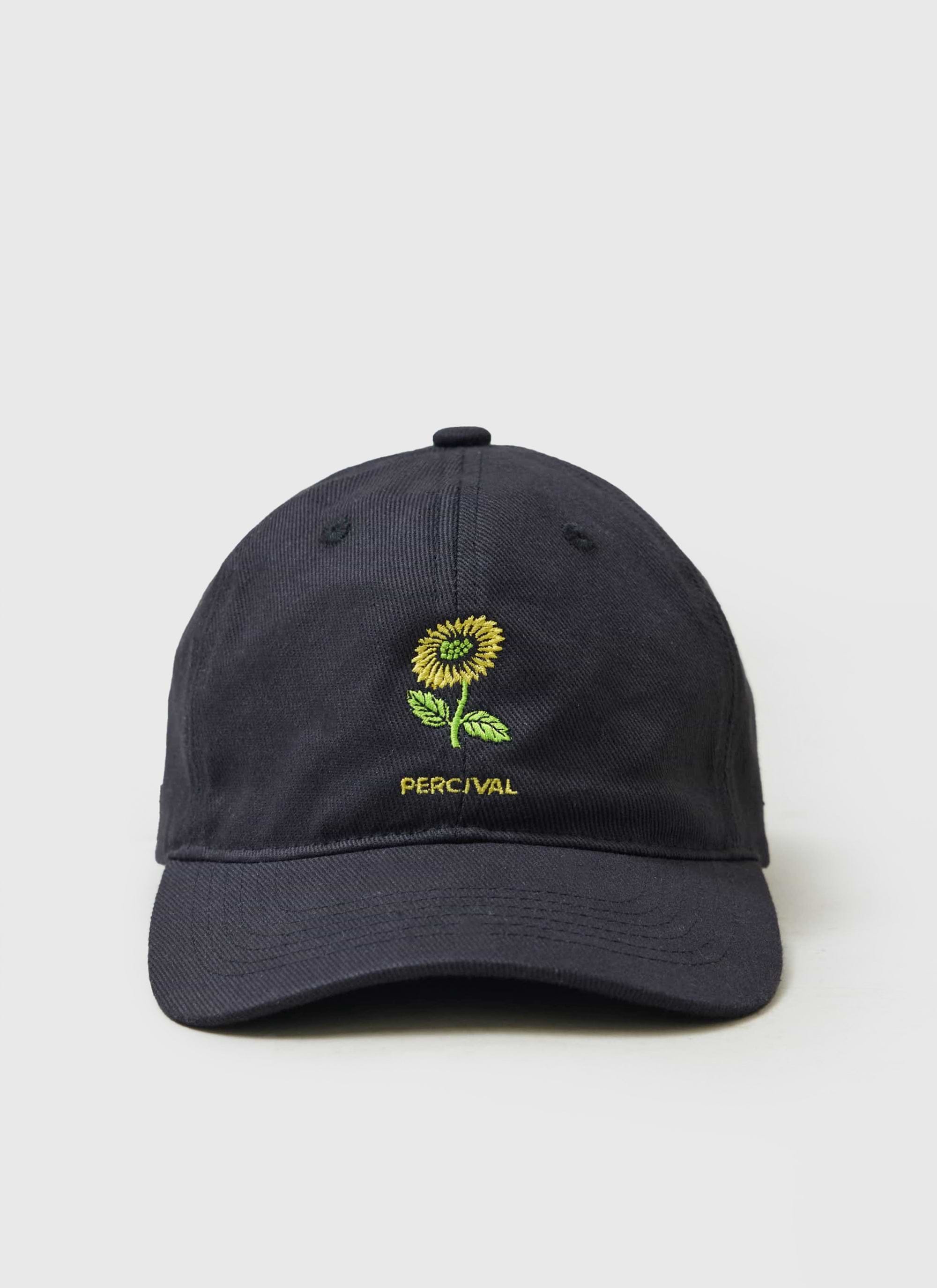 The black Percival Nature Reserve cotton cap, with a bright yellow sunflower and brand name embroidered on the front.