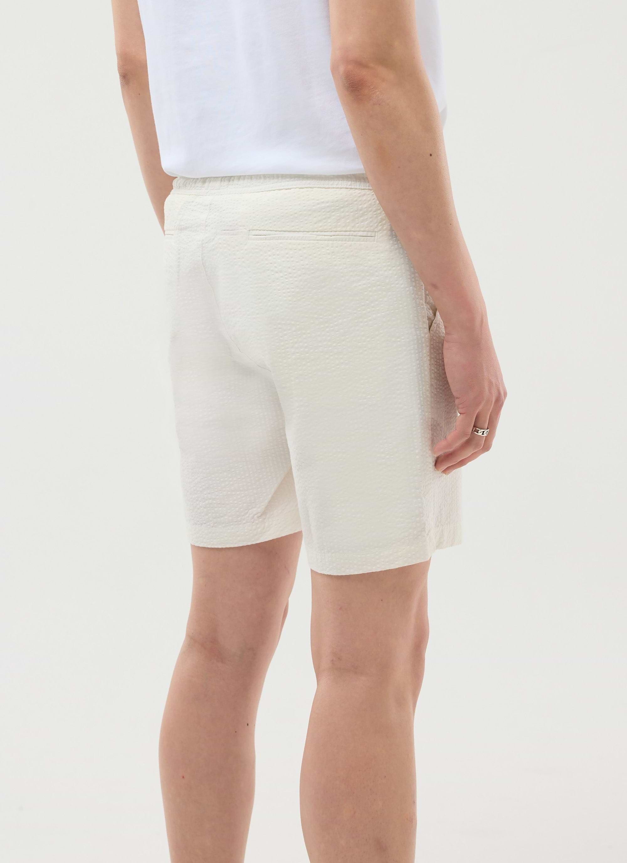 Rear view of a model wearing the Percival Classic Seersucker Shorts in cream, showing the textural fabric and fit.