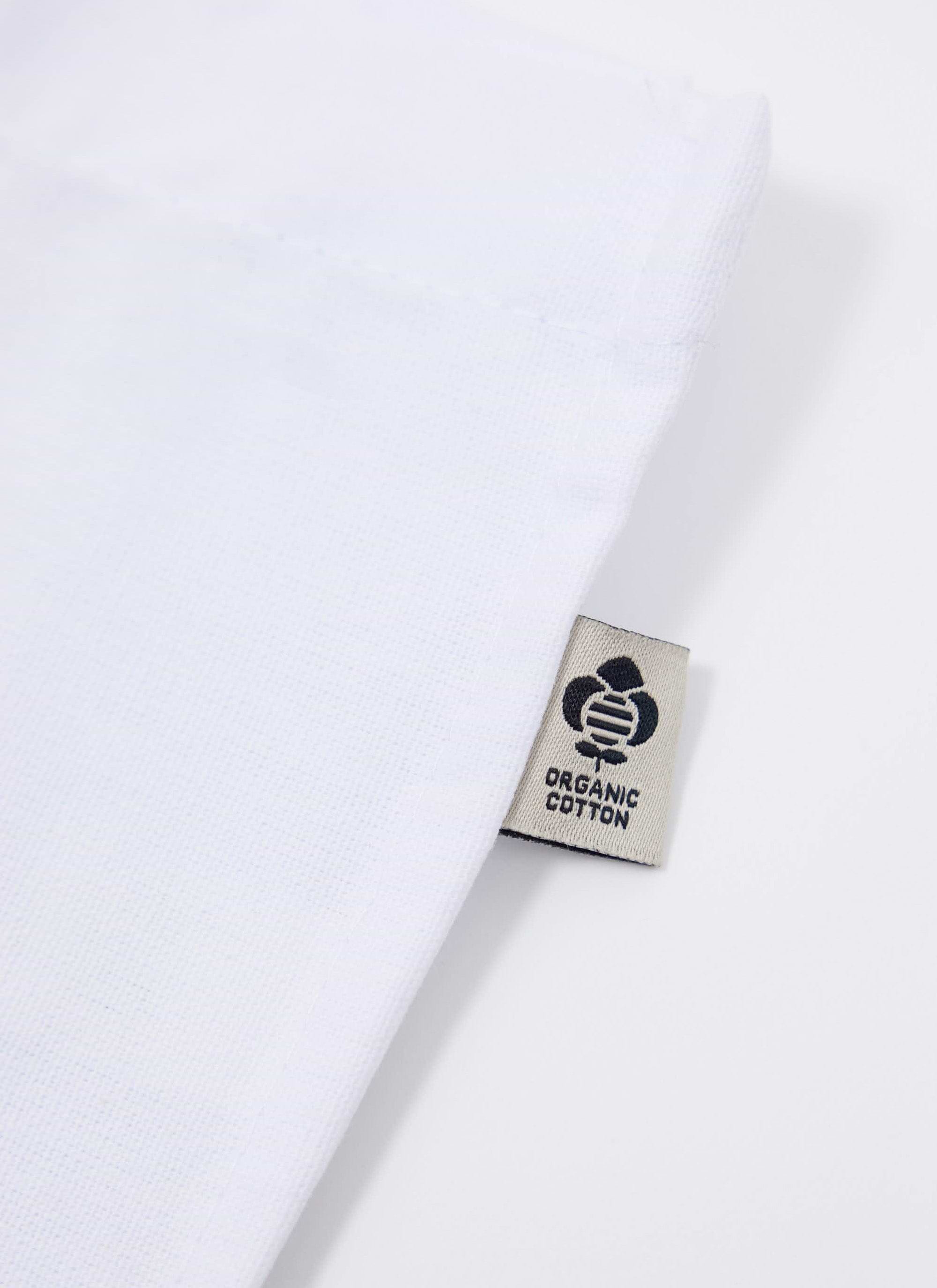 A close-up of the organic cotton tag on the Percival x The Gorilla Brand tote bag in ecru.