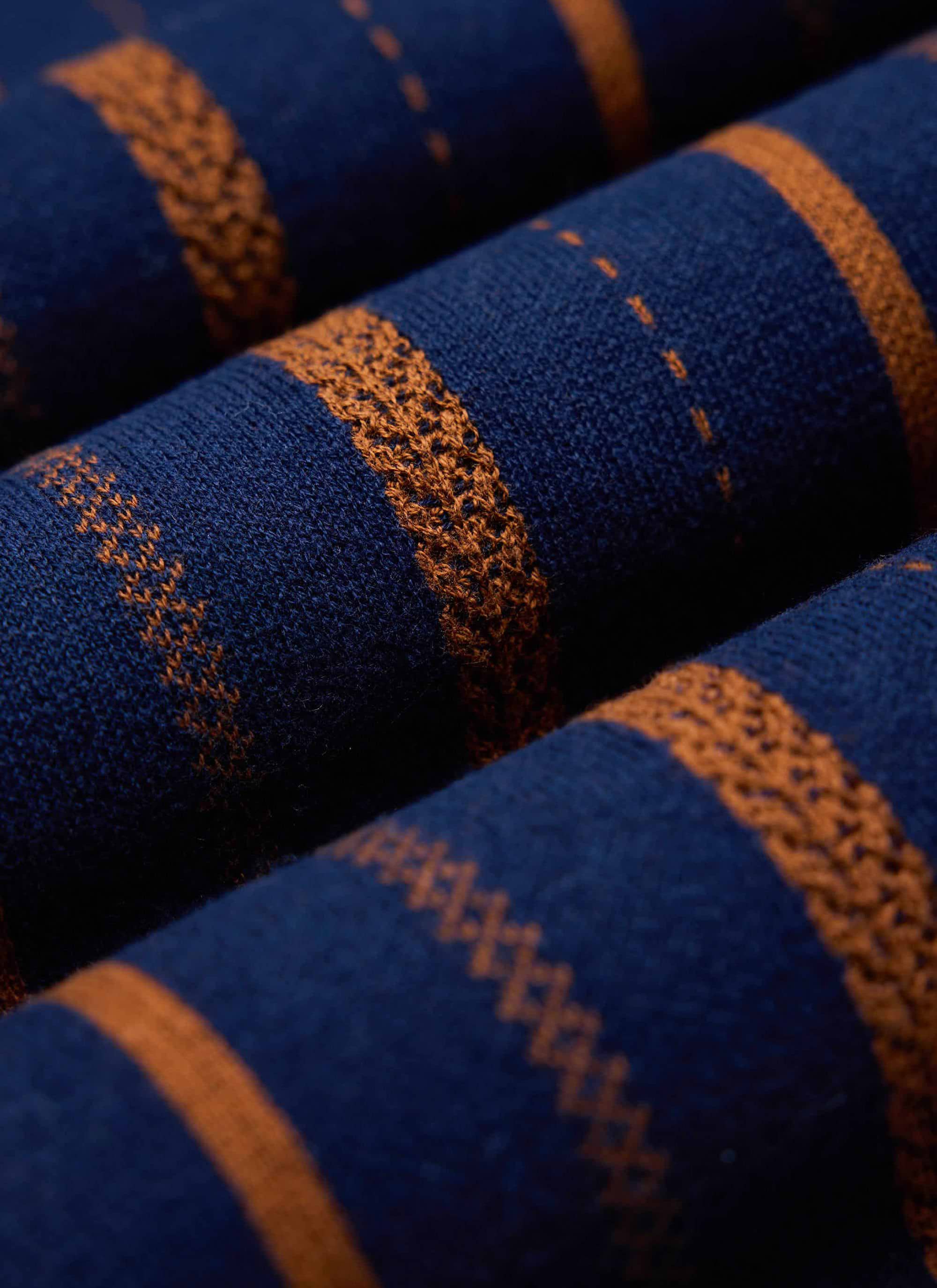 A close-up shot of the folded Percival Citation Knitted Football Shirt, highlighting the navy and orange cotton knit detail.