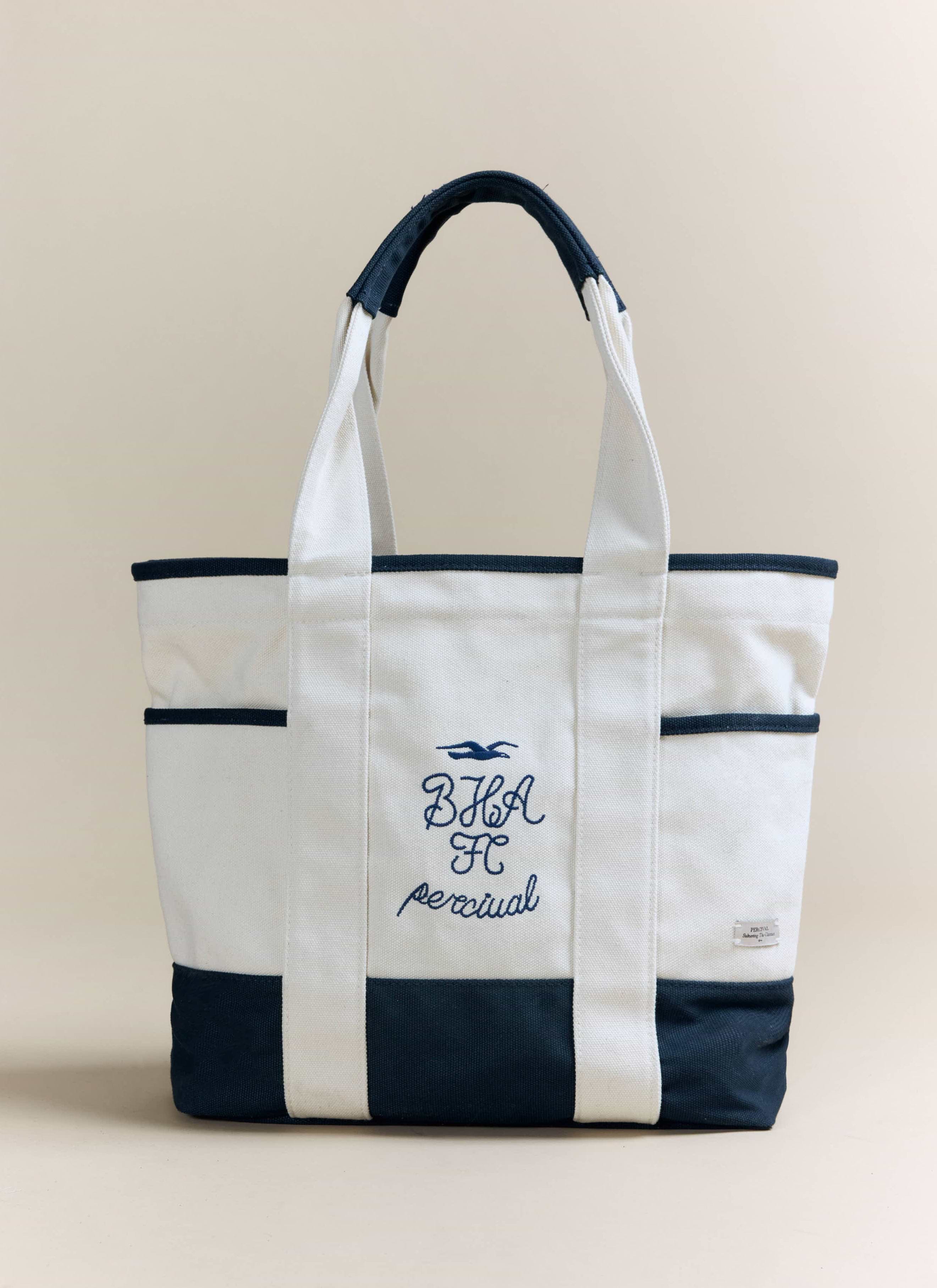 A studio shot of the Percival x Brighton & Hove Albion F.C. Tote Bag in navy and white, highlighting the embroidered logos.