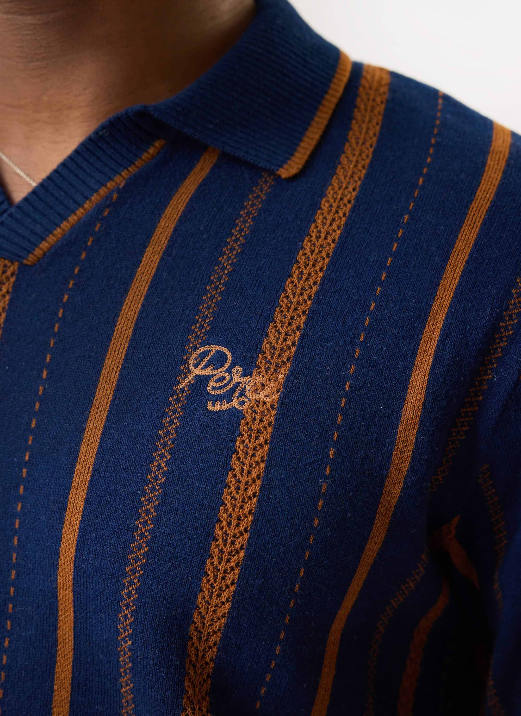 Close up on the chest of the Percival Citation Knitted Football Shirt, showing the textured stripes and logo embroidery.