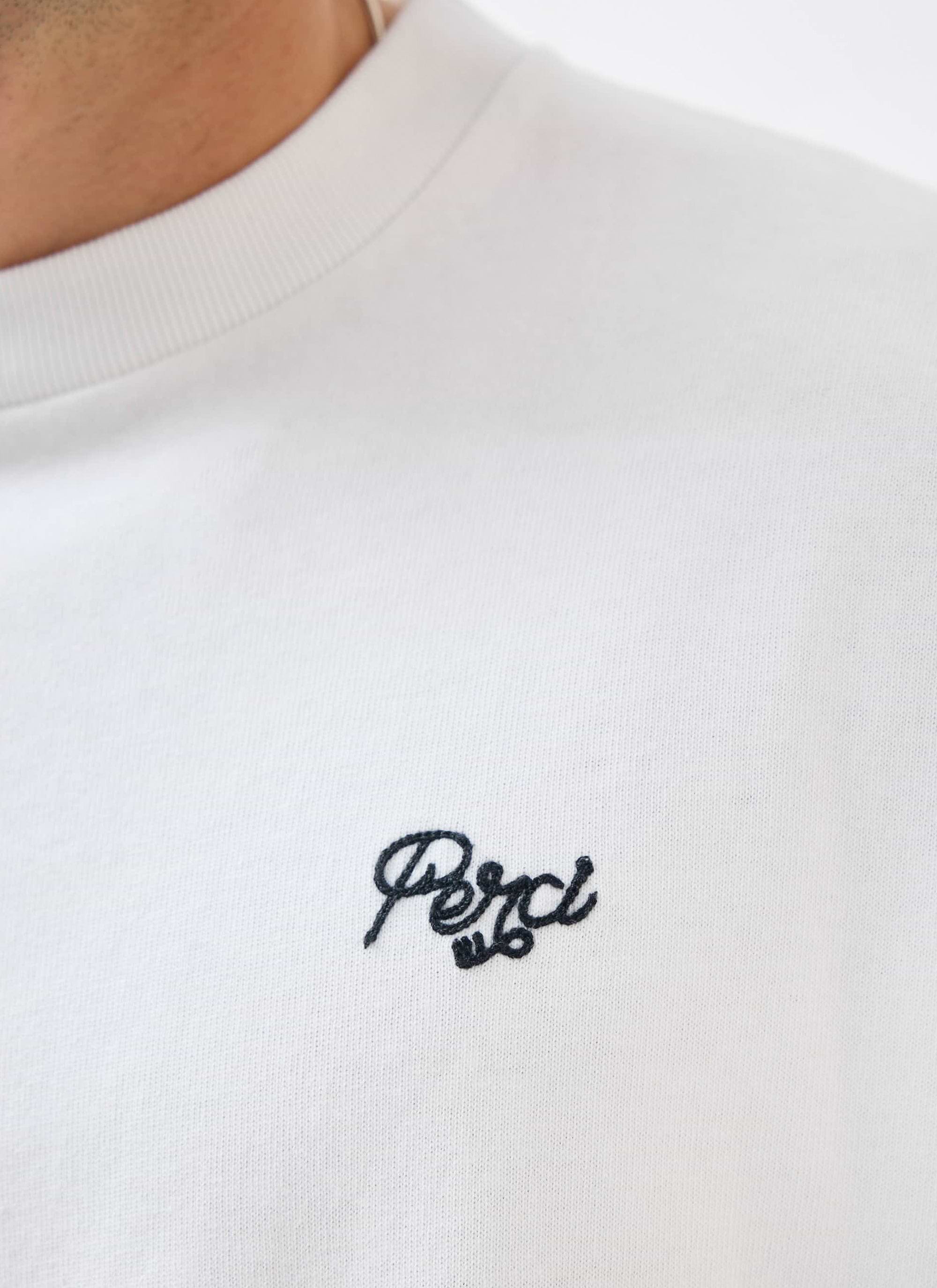 A close-up of the Percival Du Temps Oversized T-Shirt in white, showing the detailed black embroidery on the chest.