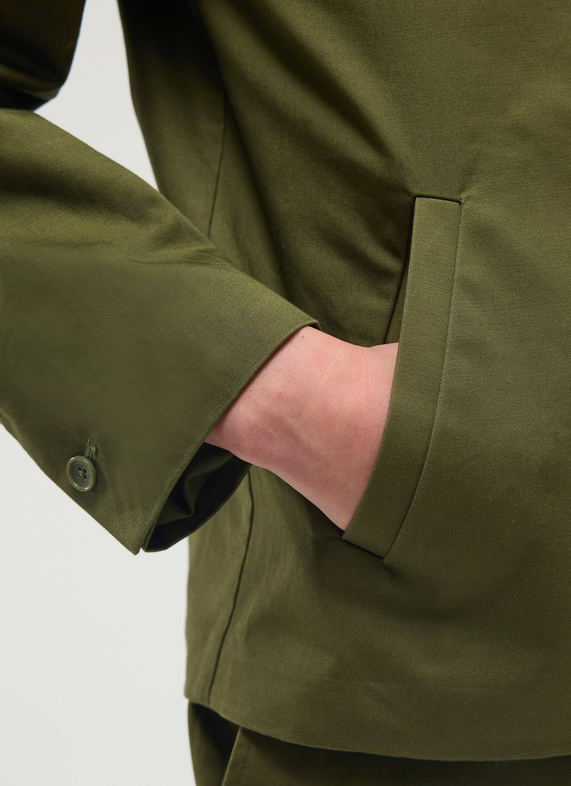 Close-up of a model's hand in the jetted pocket of the khaki cotton Casual Workwear Jacket by Percival.