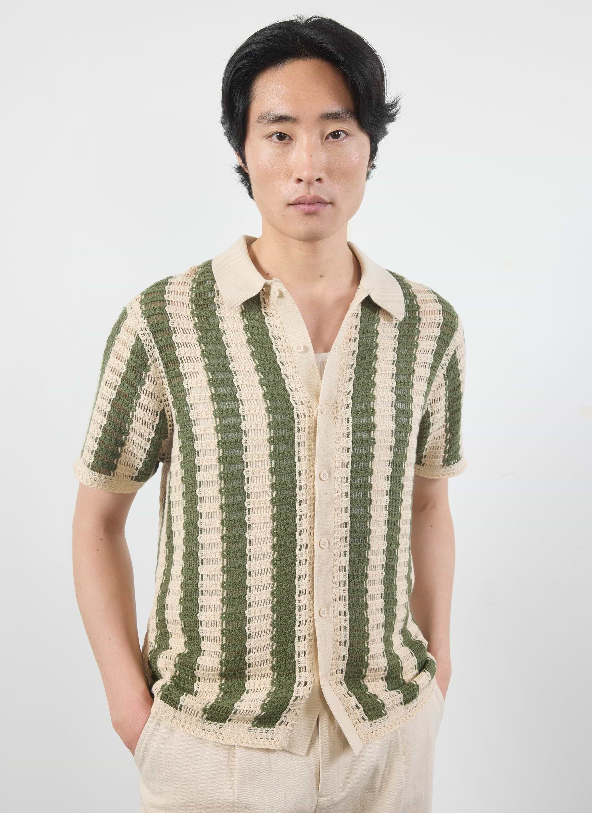 A model wears the Percival Barletta Knitted Shirt, a cotton crochet shirt with vertical olive and cream stripes.