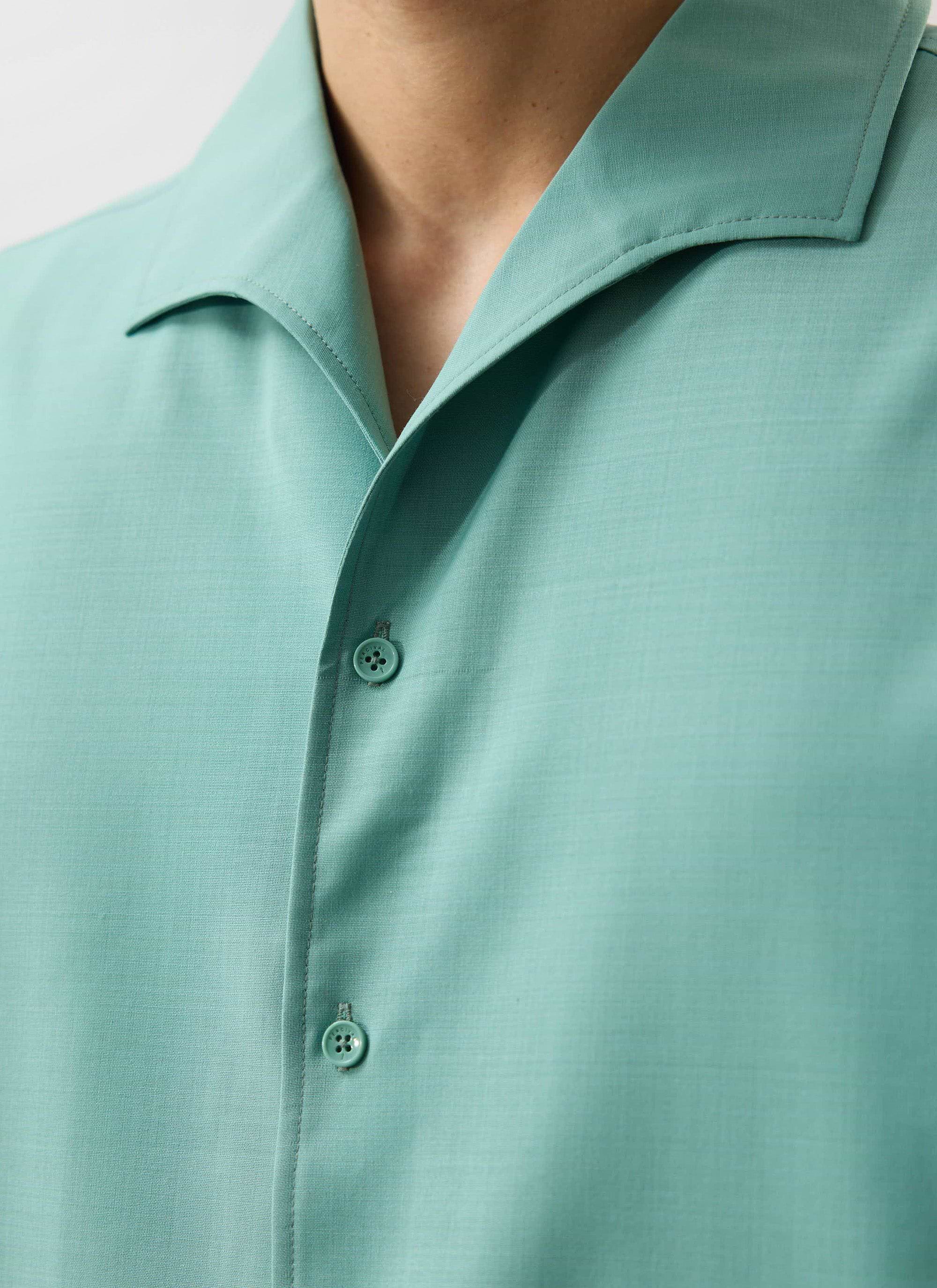 A close-up of the mint green Percival Drape Cuban shirt, showing the custom buttons, placket, and revere collar detail.