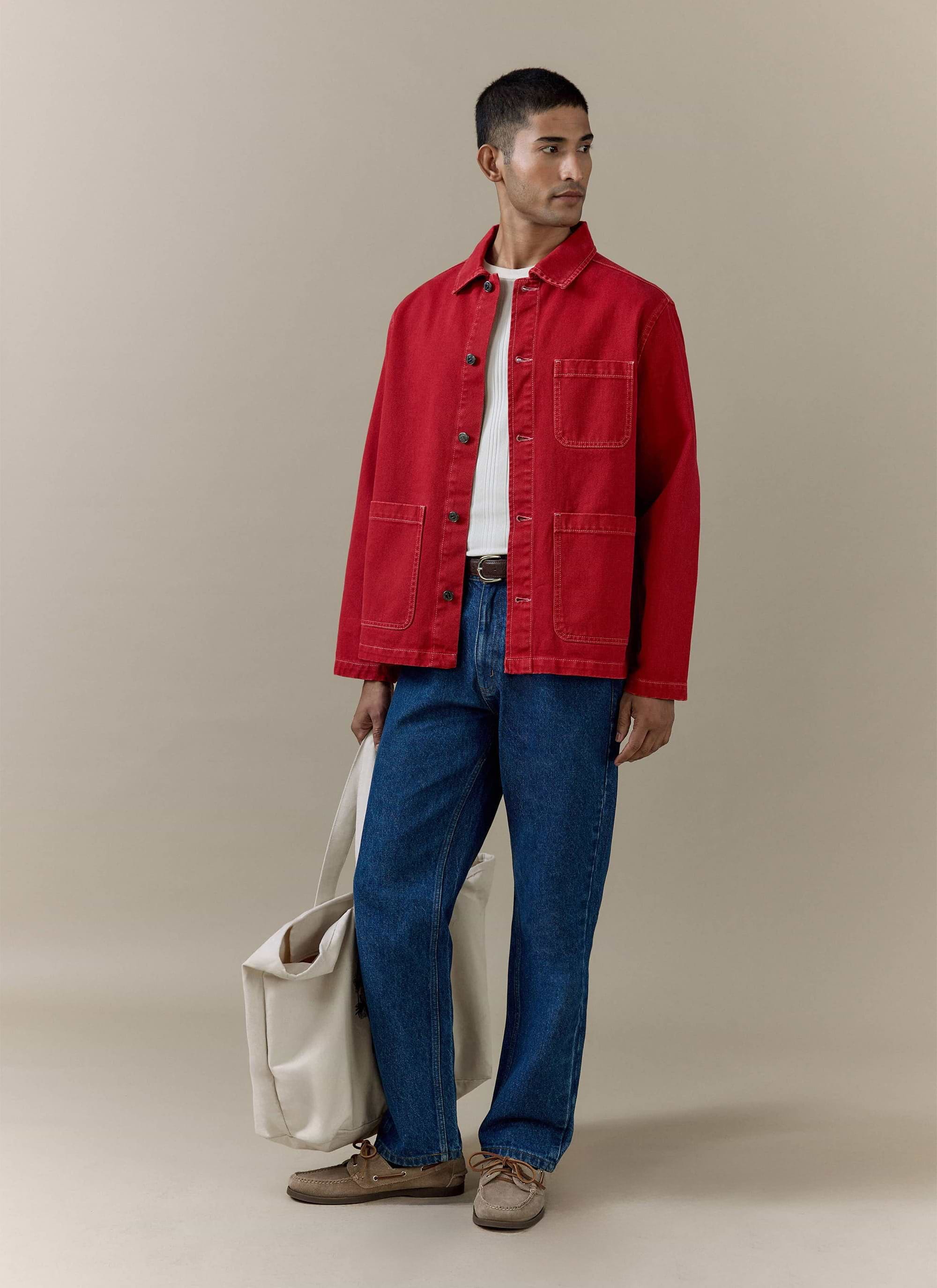 Red cotton canvas Percival Oliver Chore Jacket styled on a model with blue jeans and a cream tote bag.