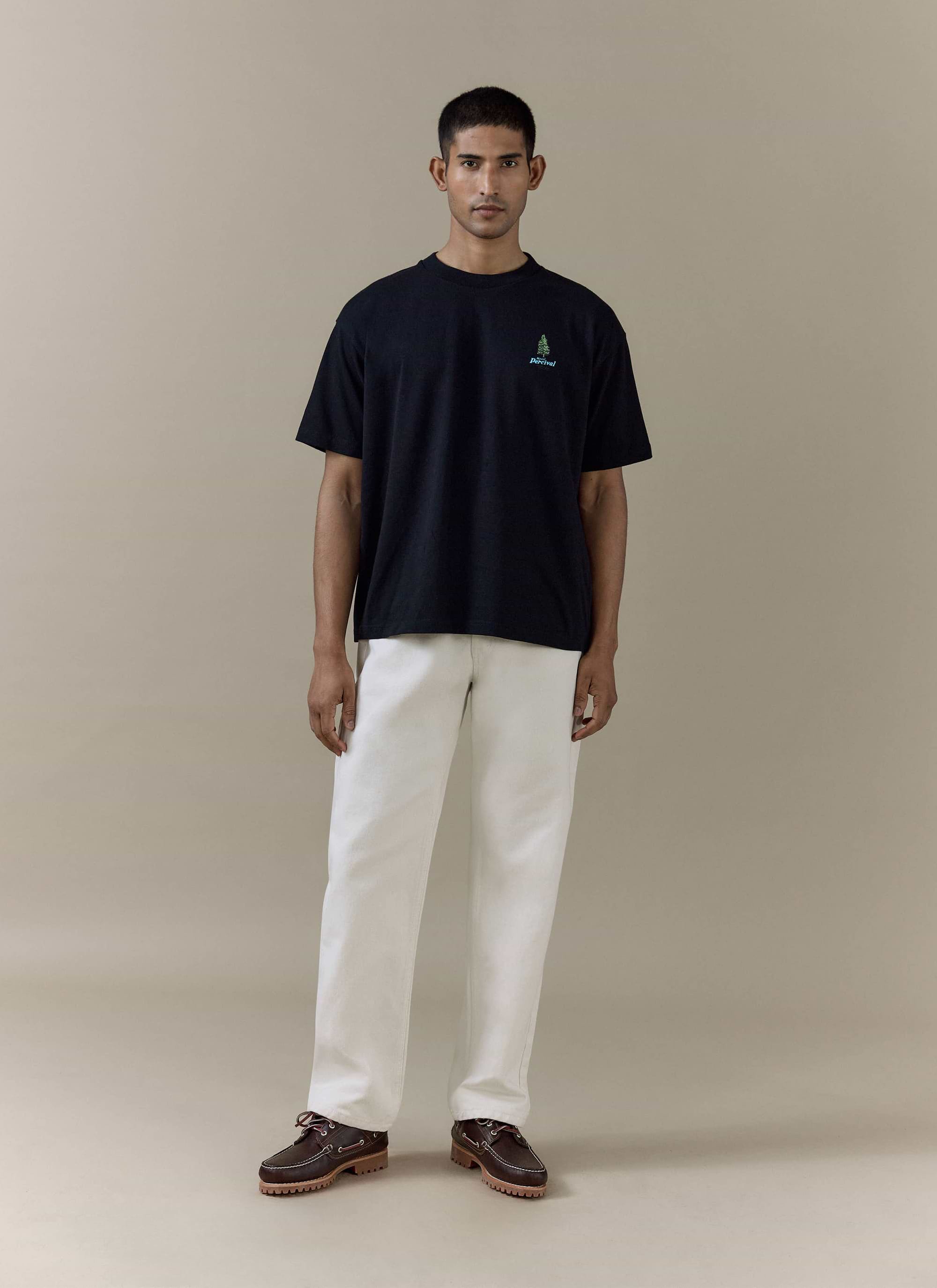 Black organic cotton Arnold Oversized T Shirt by Percival, featuring a small green tree chest graphic on a model.