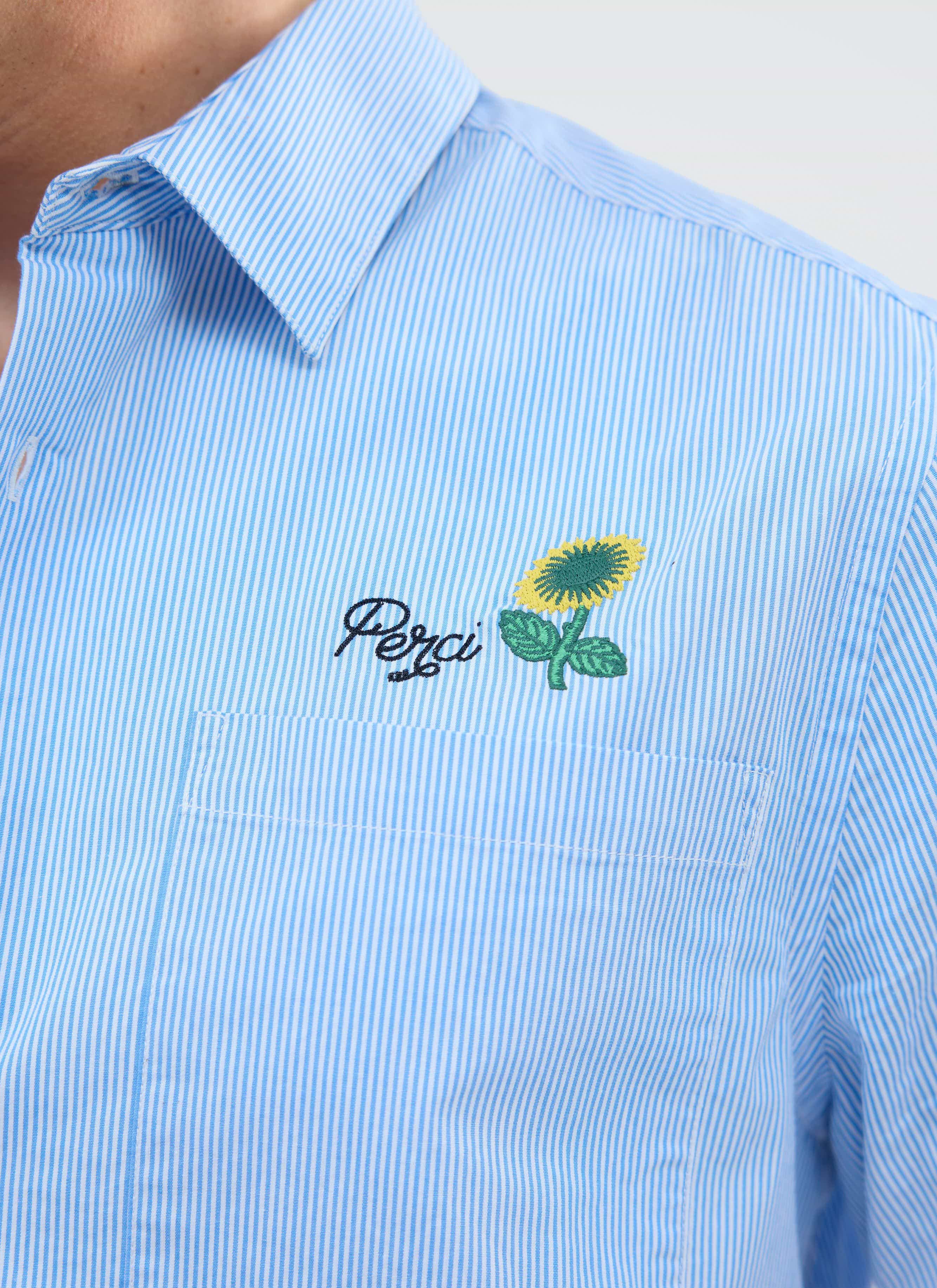 A close-up of the Percival Sunflower Stripe Shirt, showing the blue and white stripe fabric and sunflower embroidery detail.